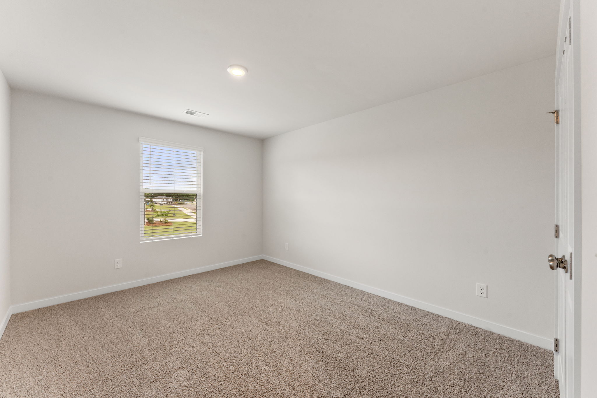A room with a window and a carpet.