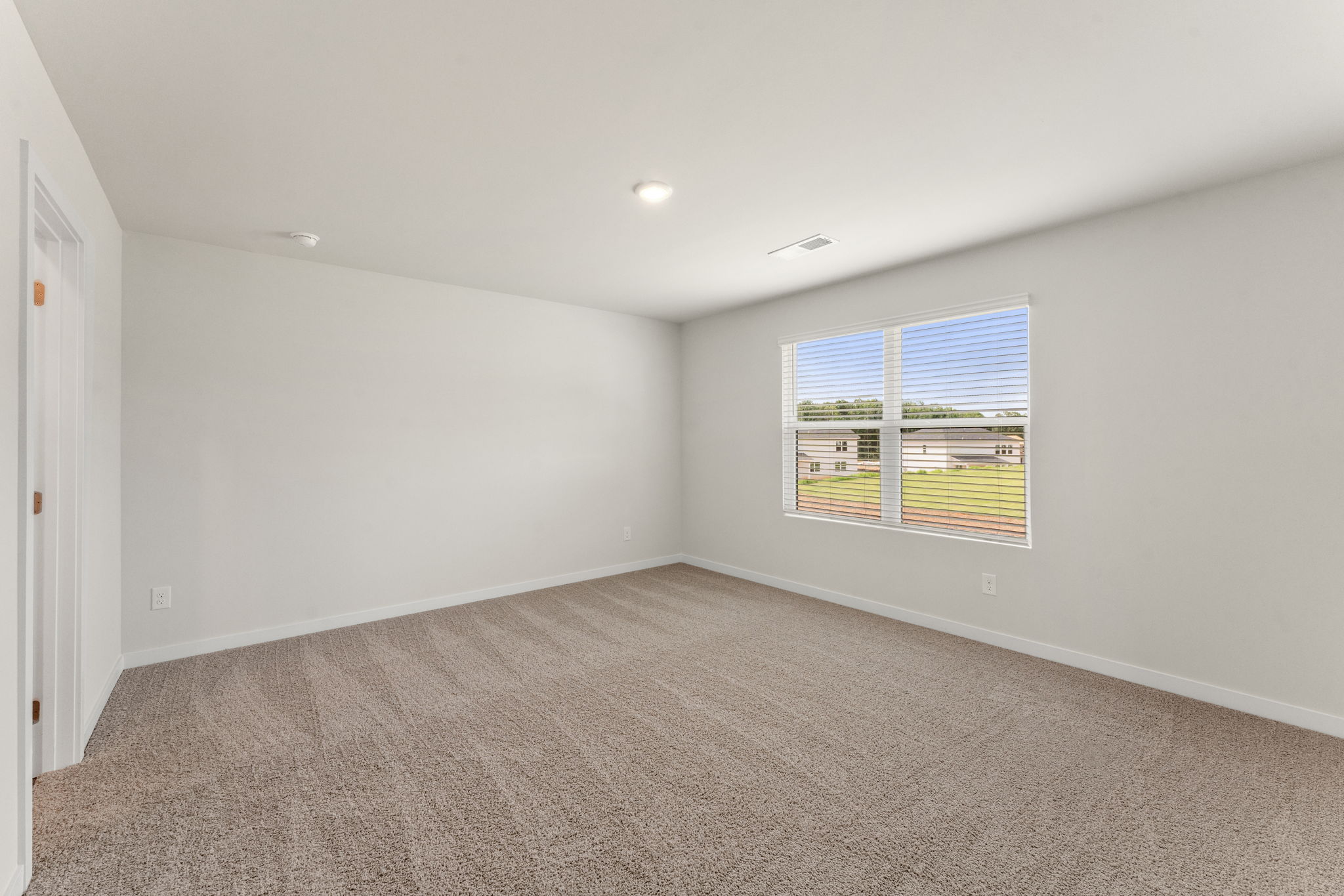 A room with a window and a carpet.
