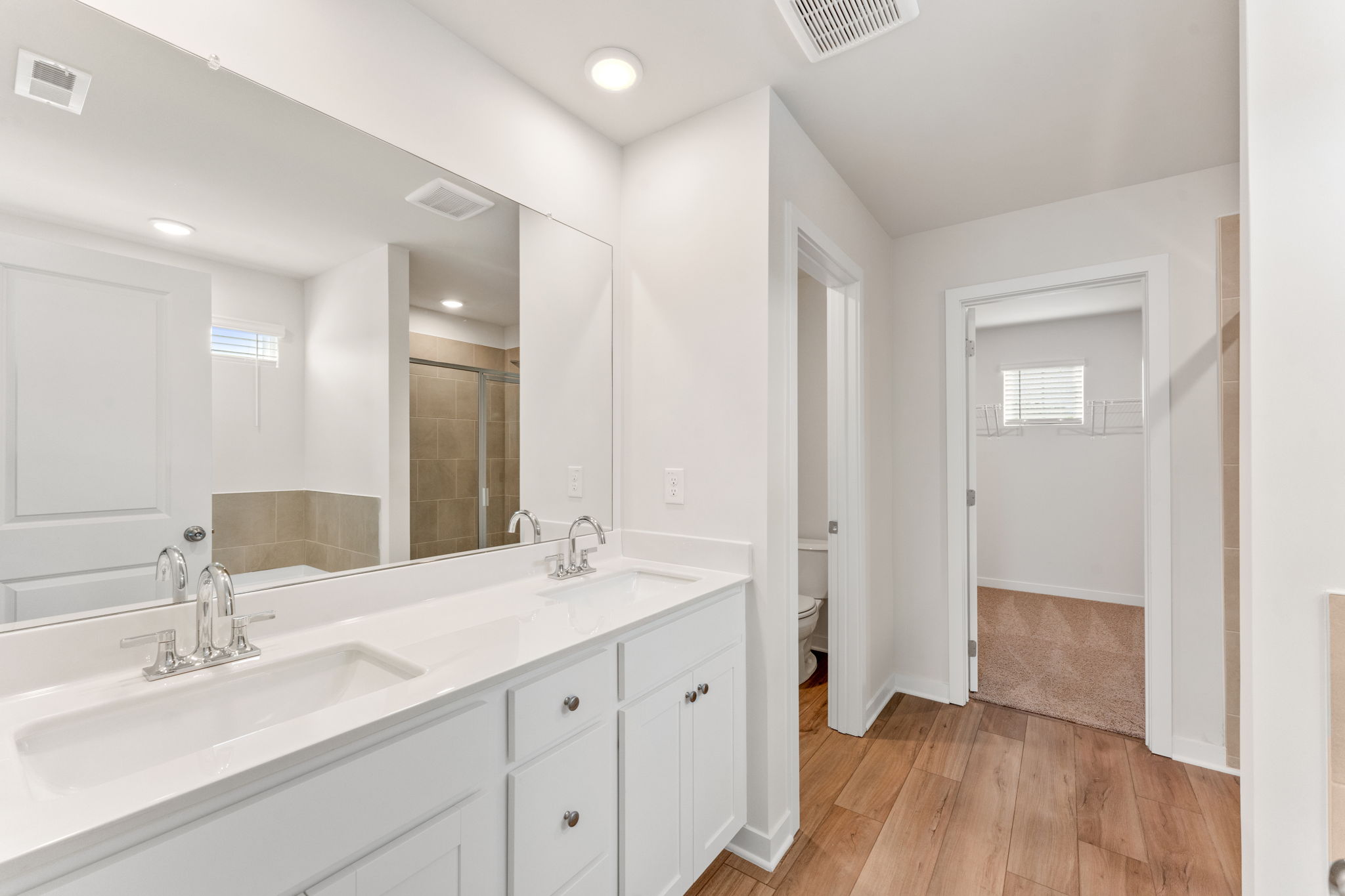 A bathroom with white cabinets.