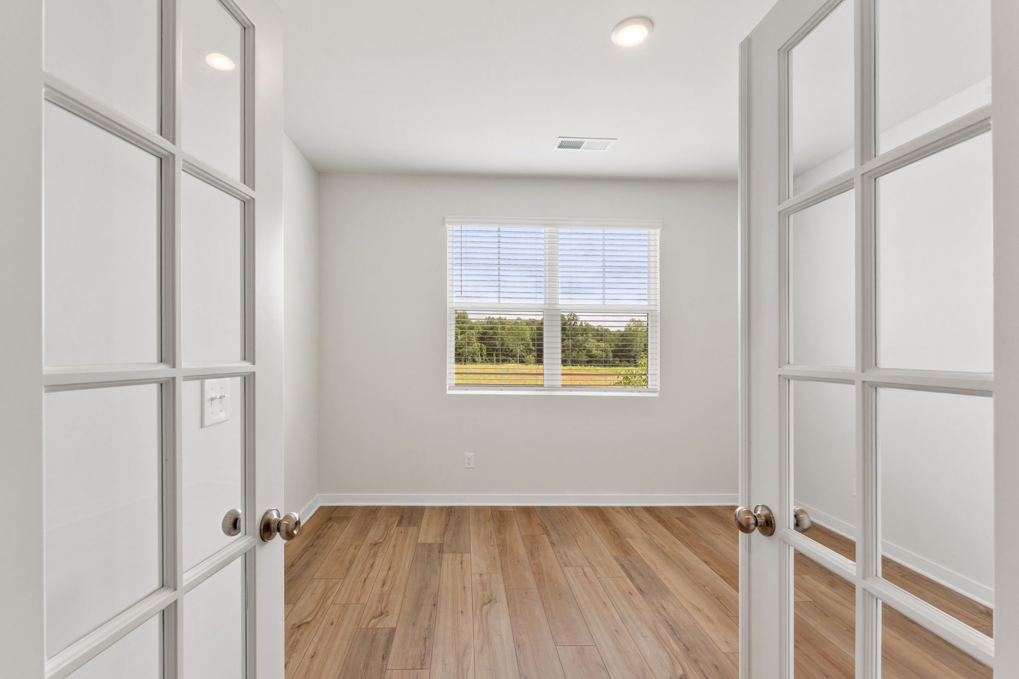 A room with white doors and a window.