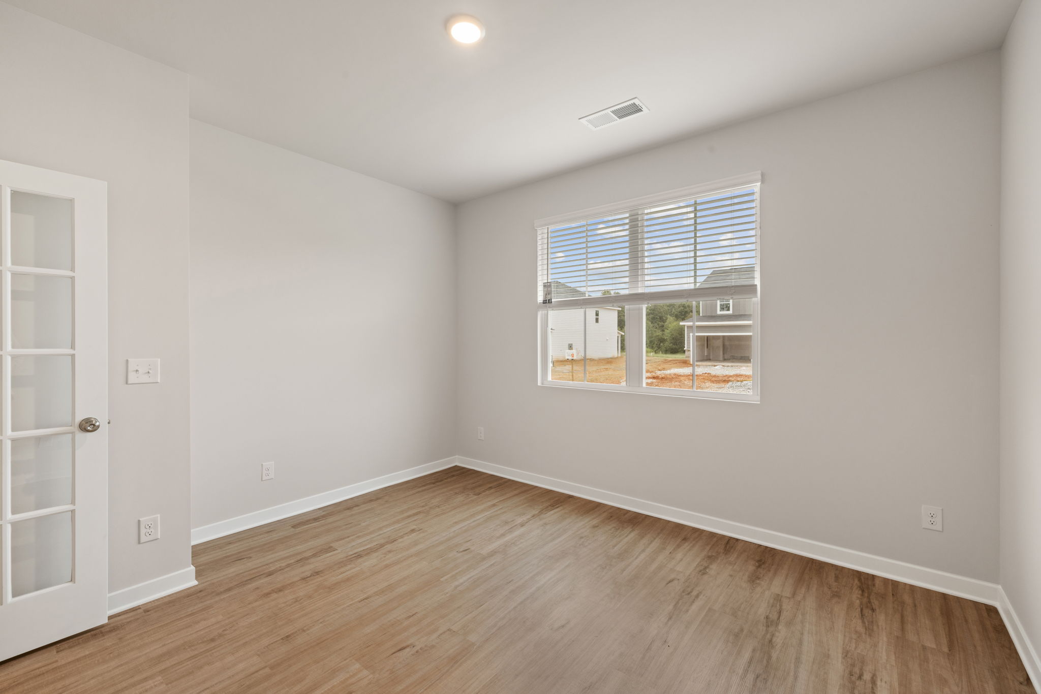 A room with a wood floor and a window.
