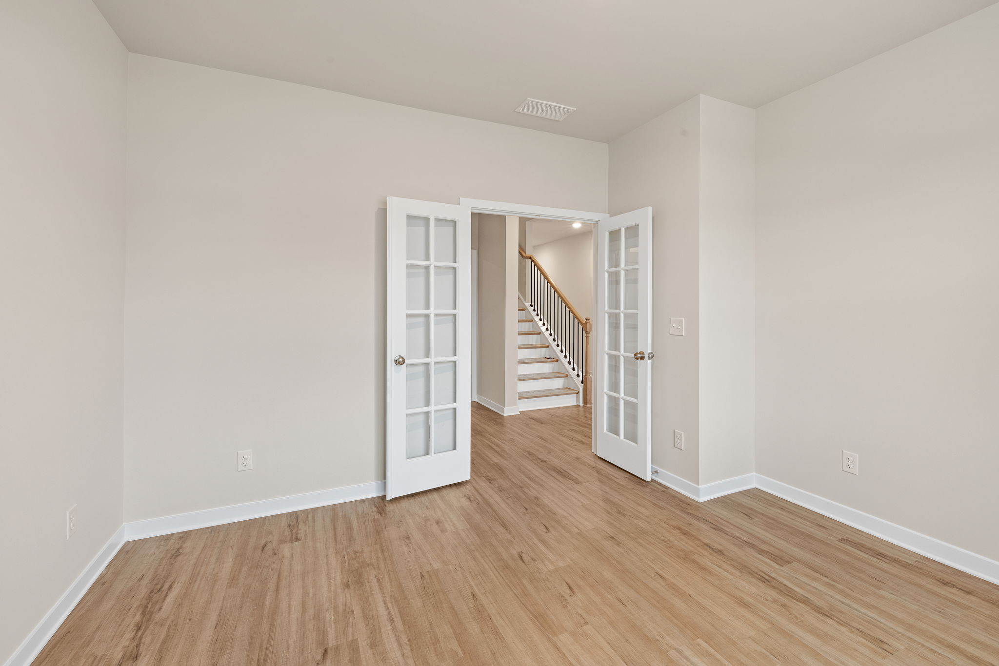 A room with white walls and a wood floor.