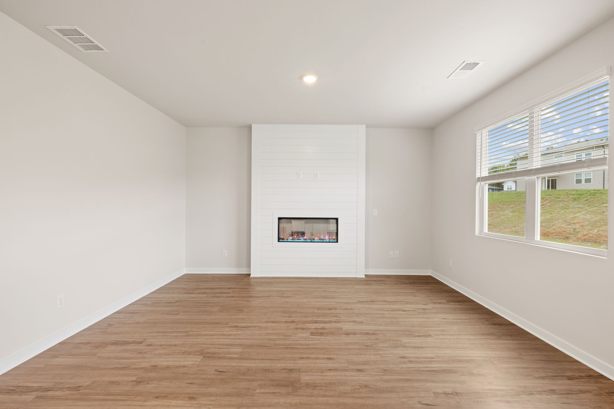 A room with a wood floor and a window.