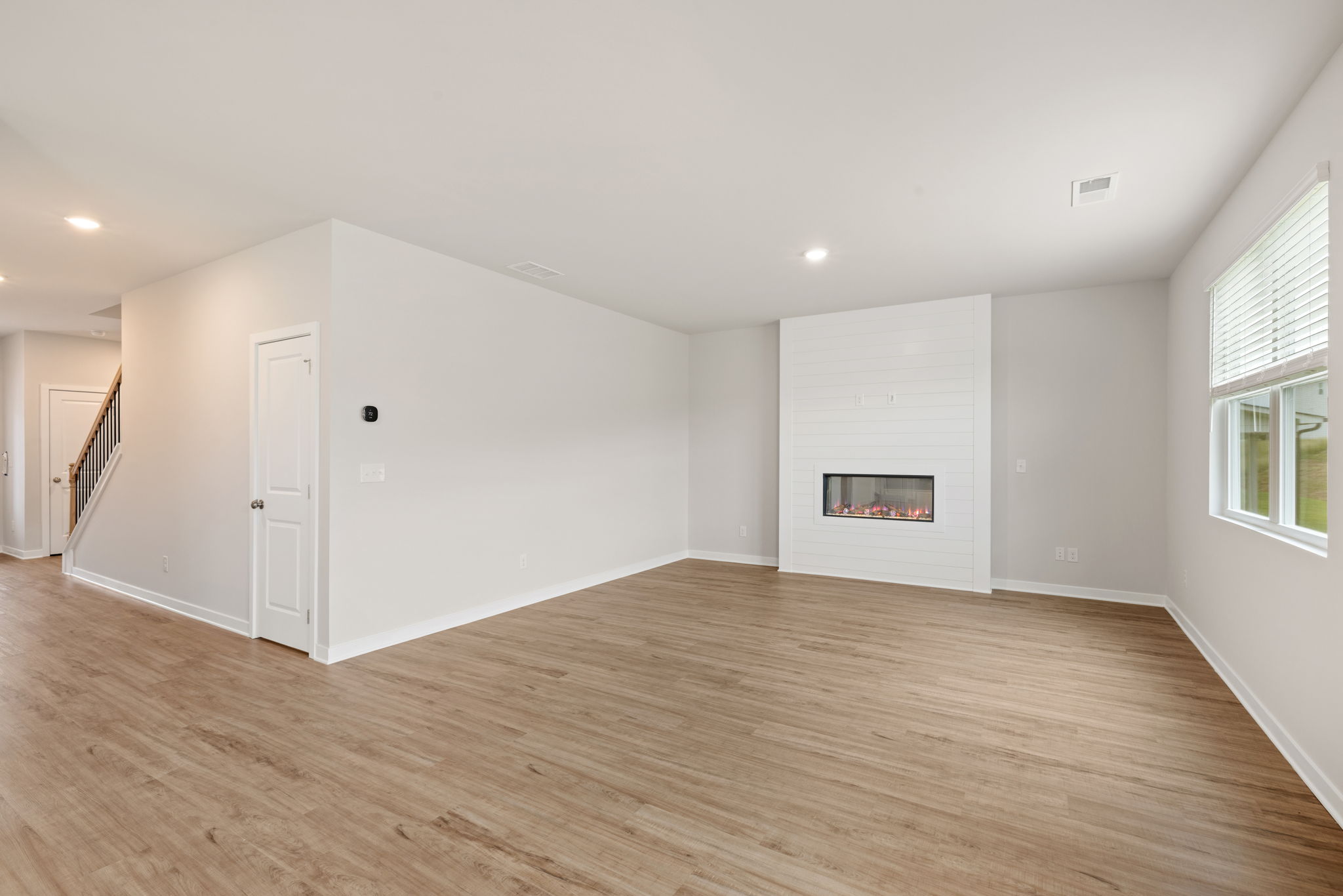 A room with a fireplace and a wood floor.