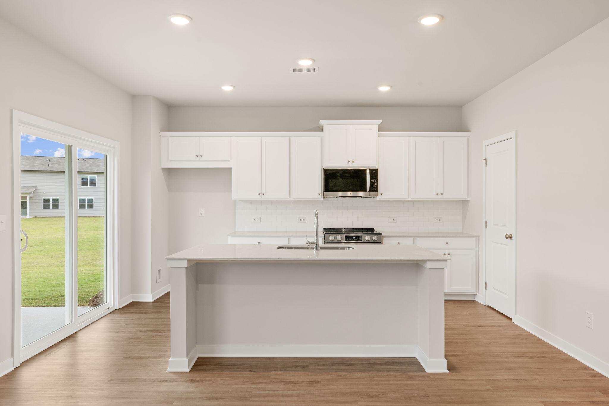 A kitchen with white cabinets.