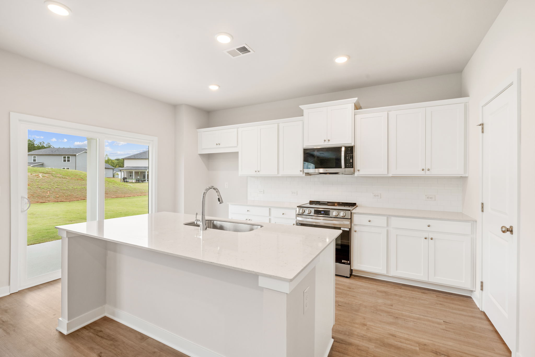 A kitchen with white cabinets.