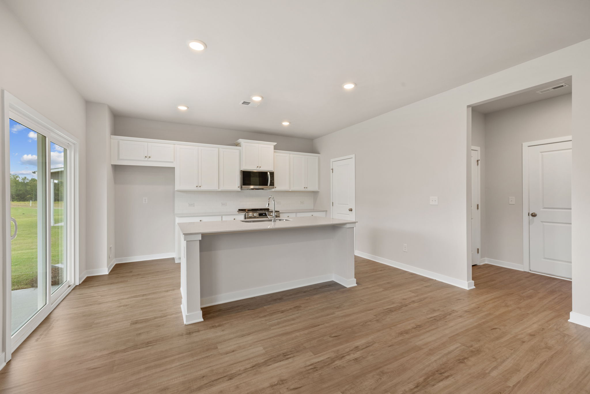 A kitchen with white cabinets.
