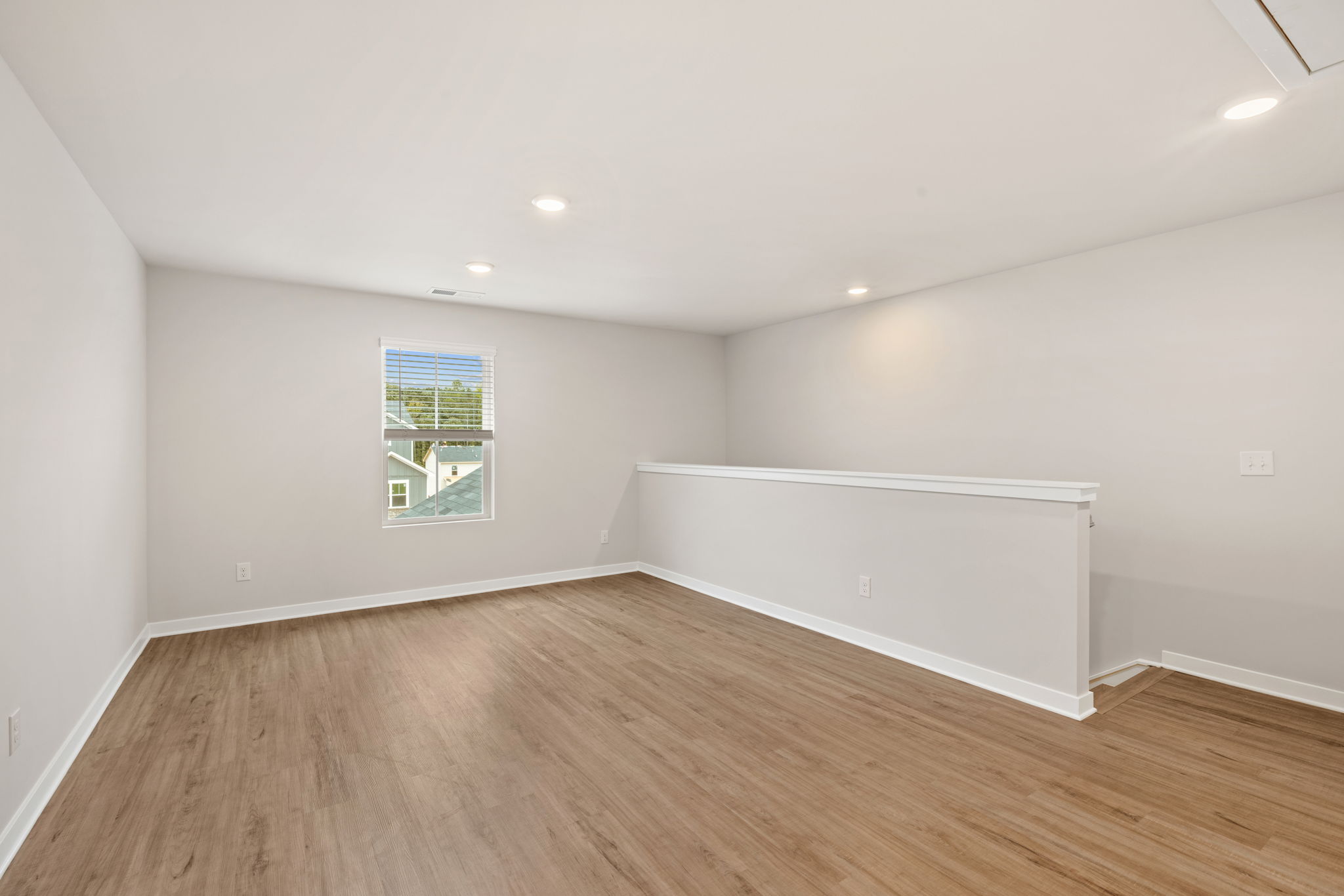 A room with a wood floor and a window.