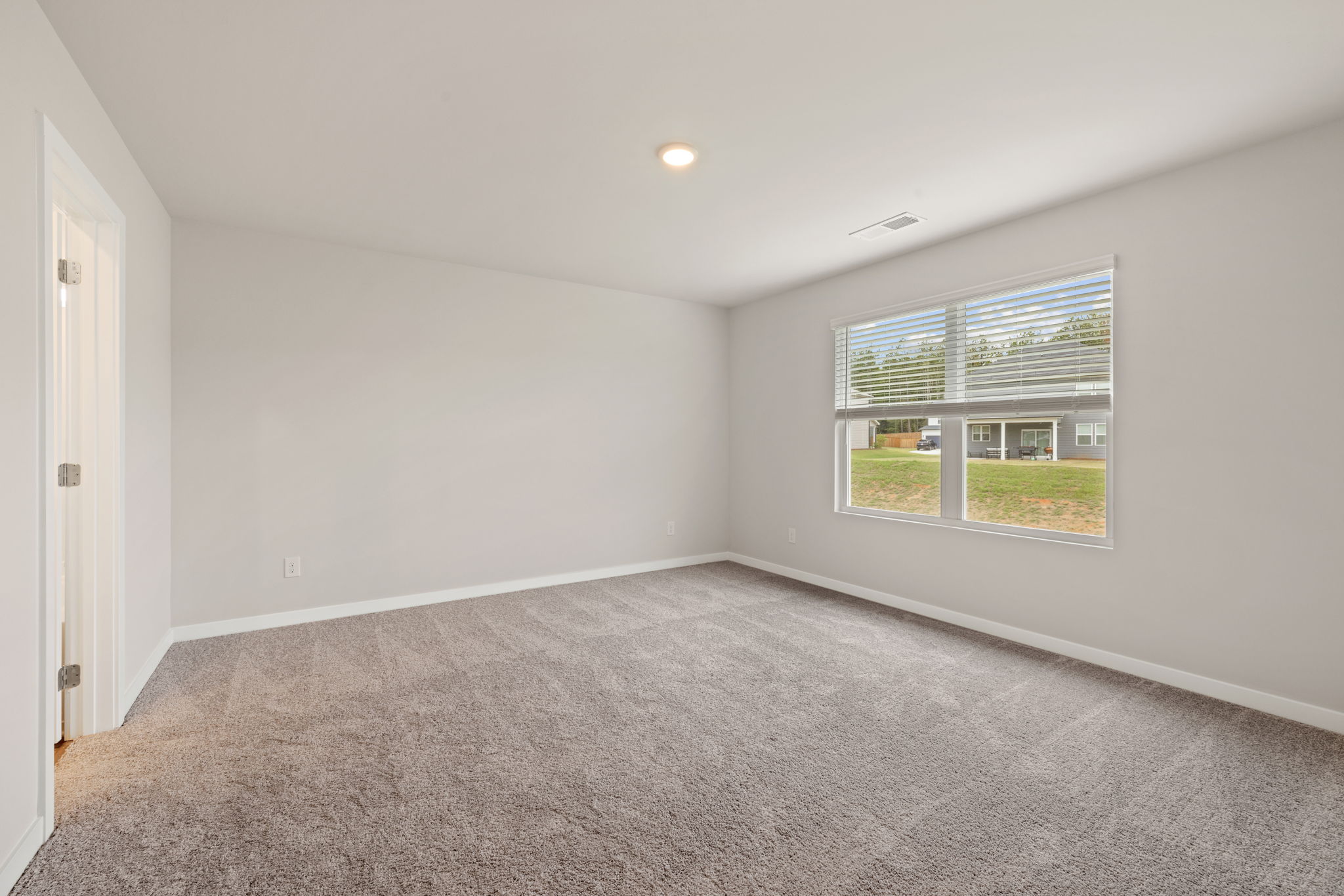 A room with a window and a carpet.