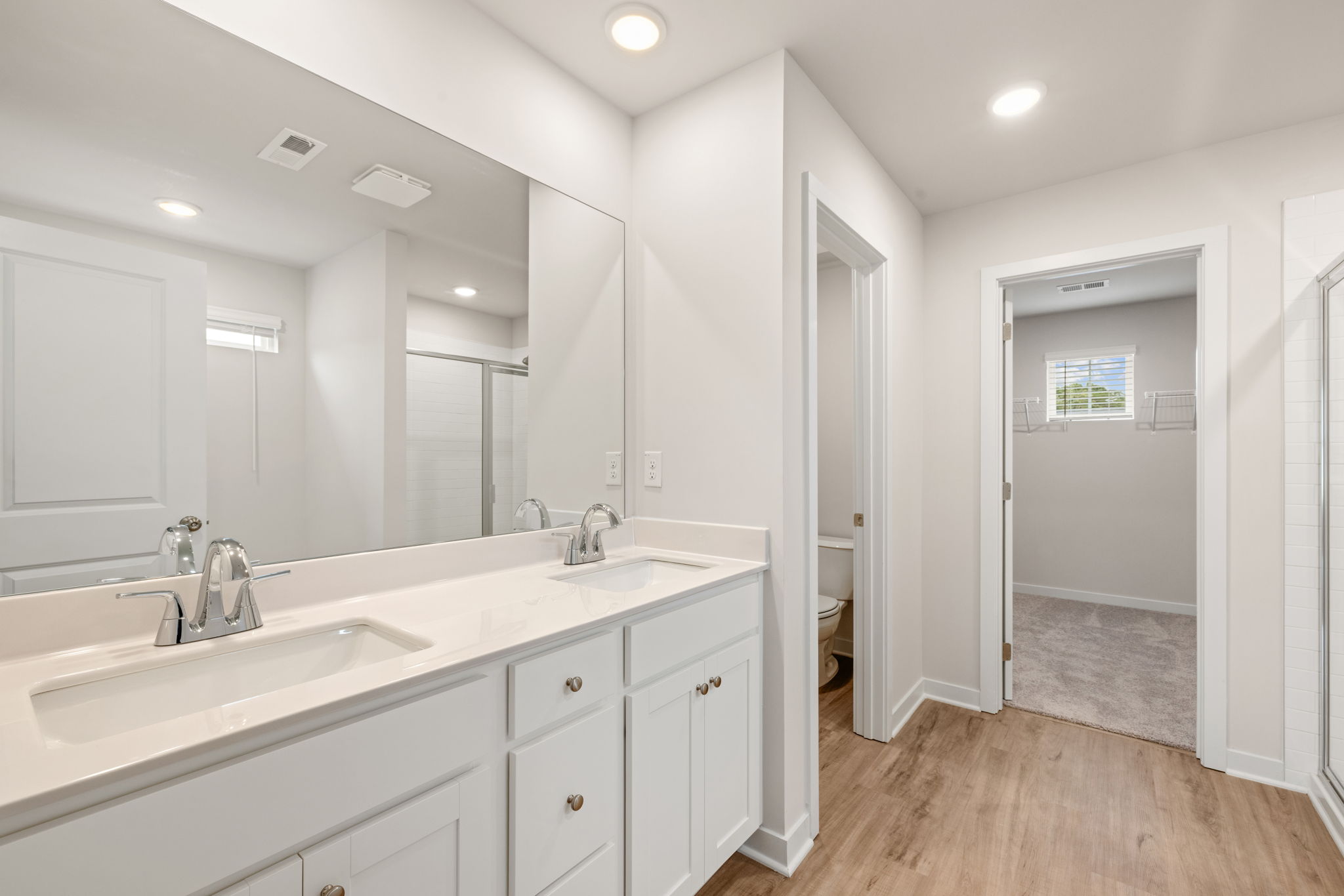 A bathroom with white cabinets.