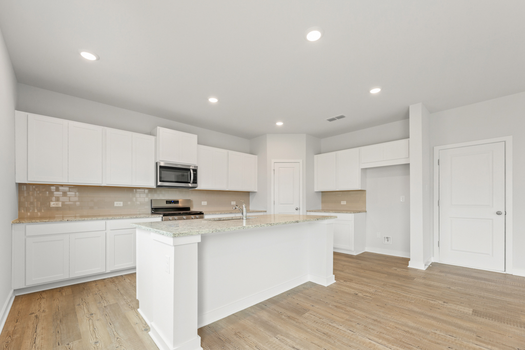 A kitchen with white cabinets.