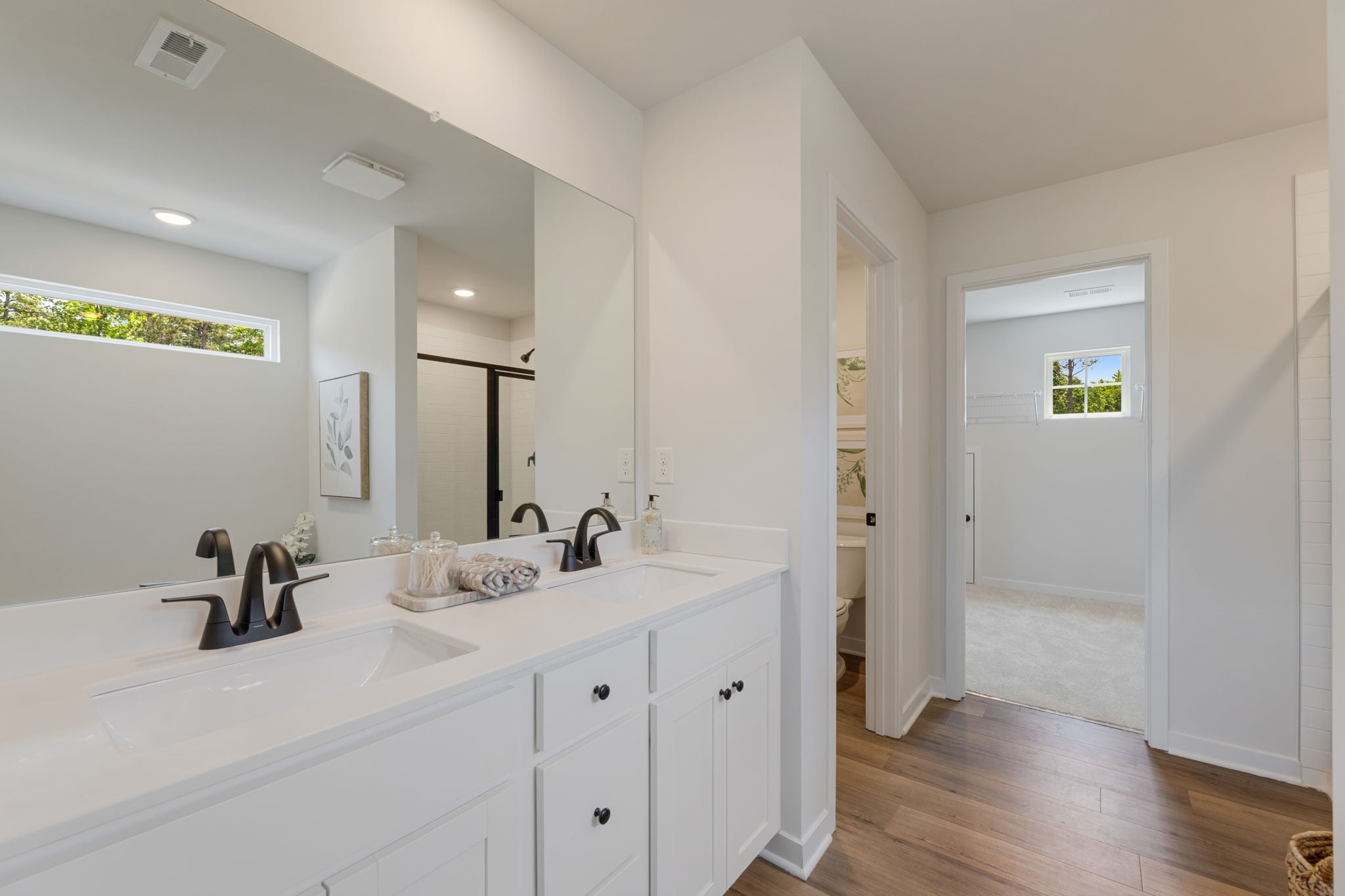 A bathroom with white cabinets.