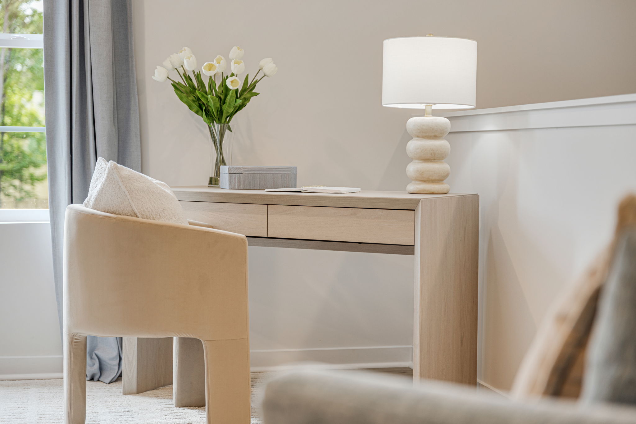 A table with a lamp and a vase of flowers on it.