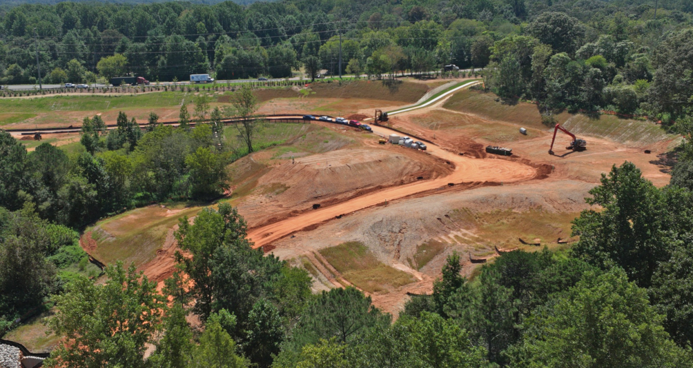 A construction site with trees and a road.
