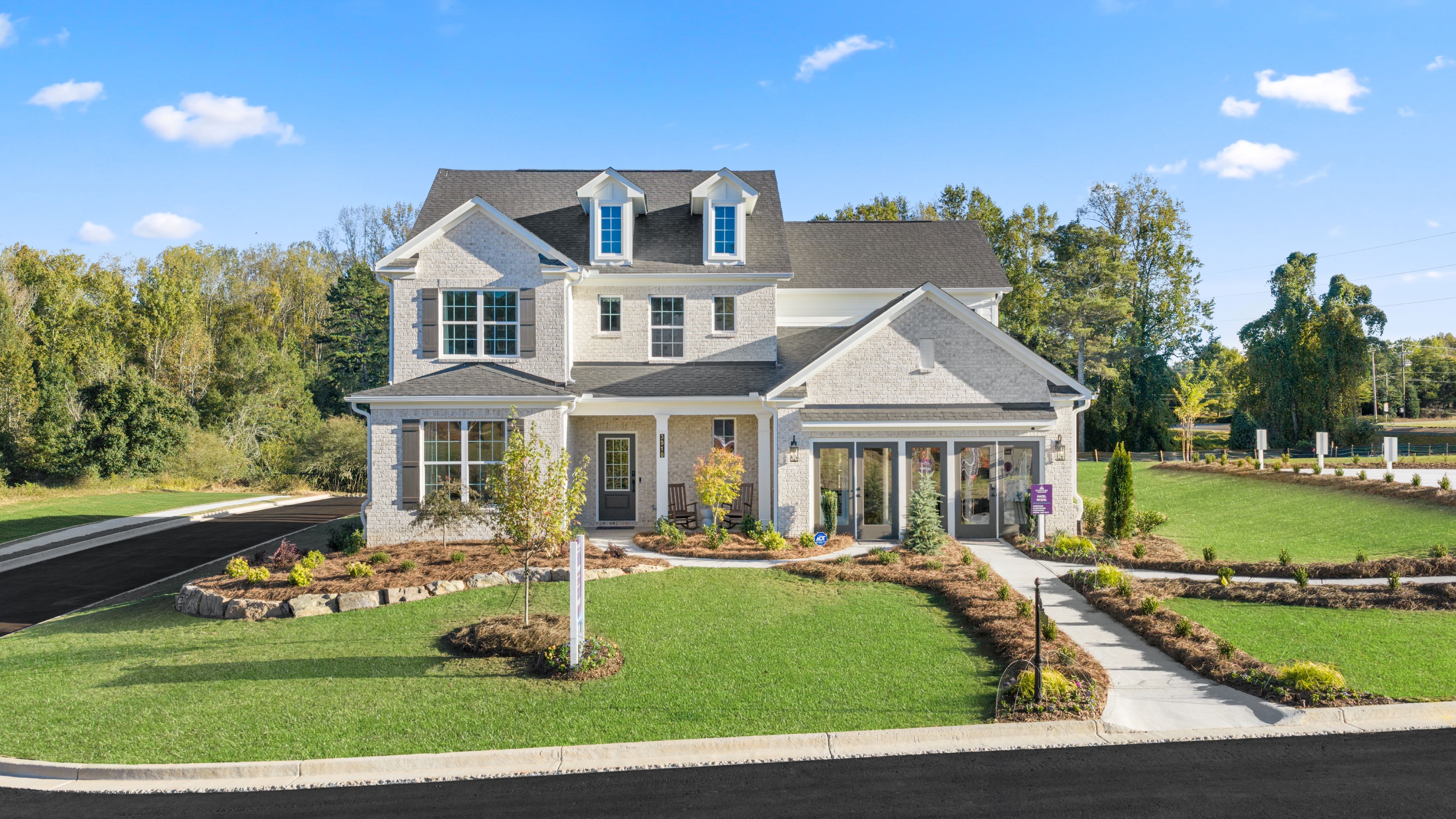 A large house with a lawn and trees in the front.
