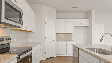 A kitchen with white cabinets.