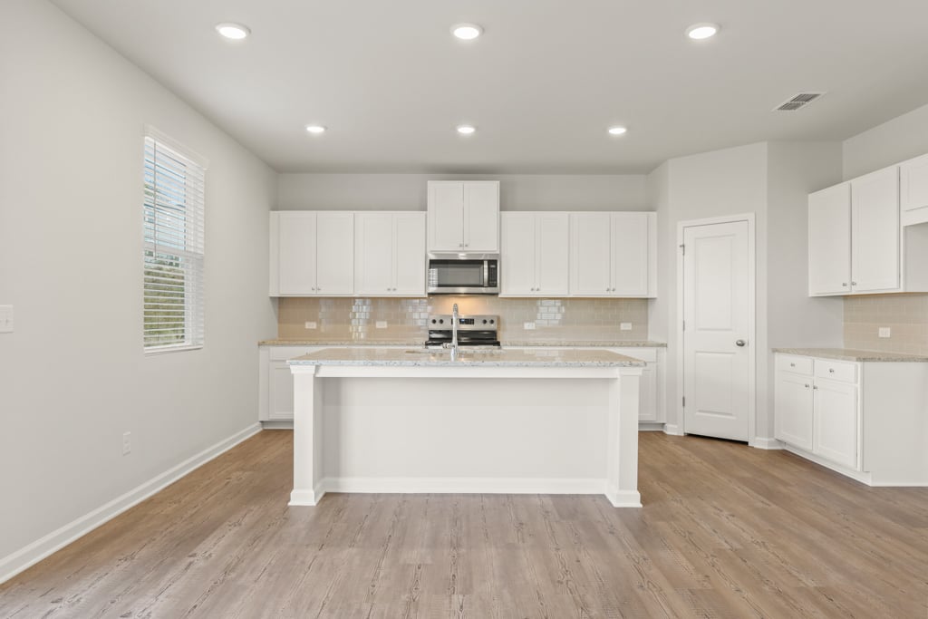 A kitchen with white cabinets.