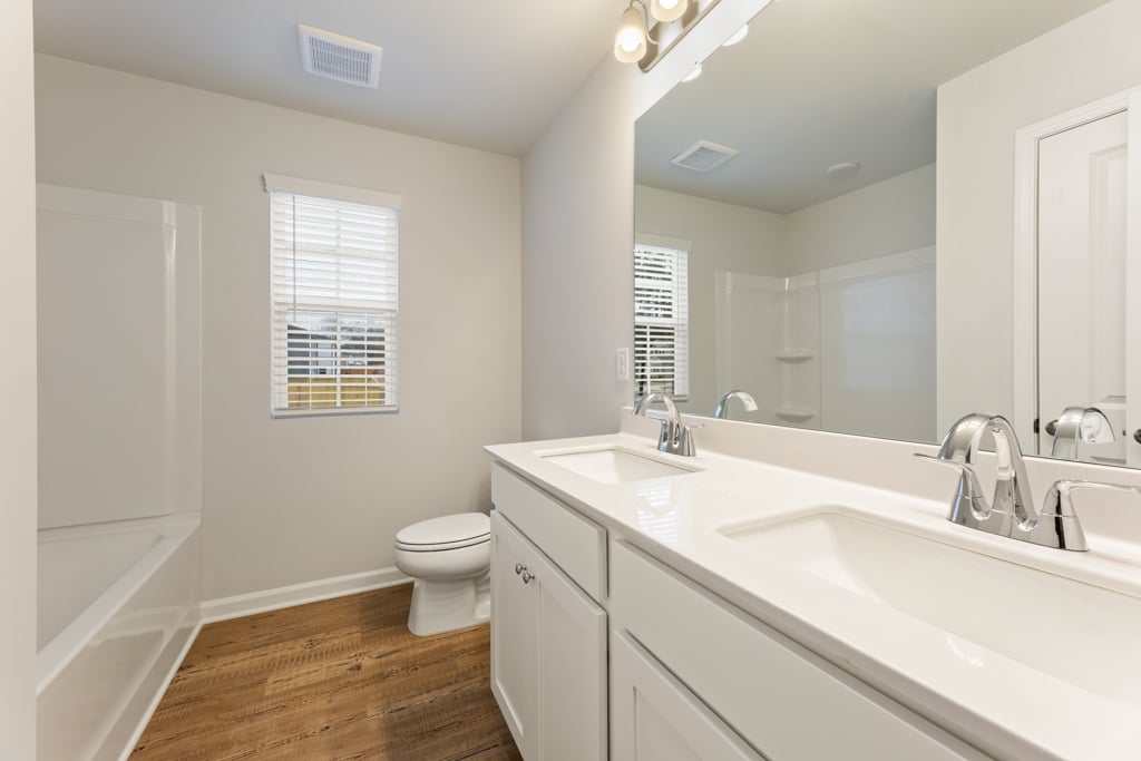 A bathroom with a tub sink and toilet.