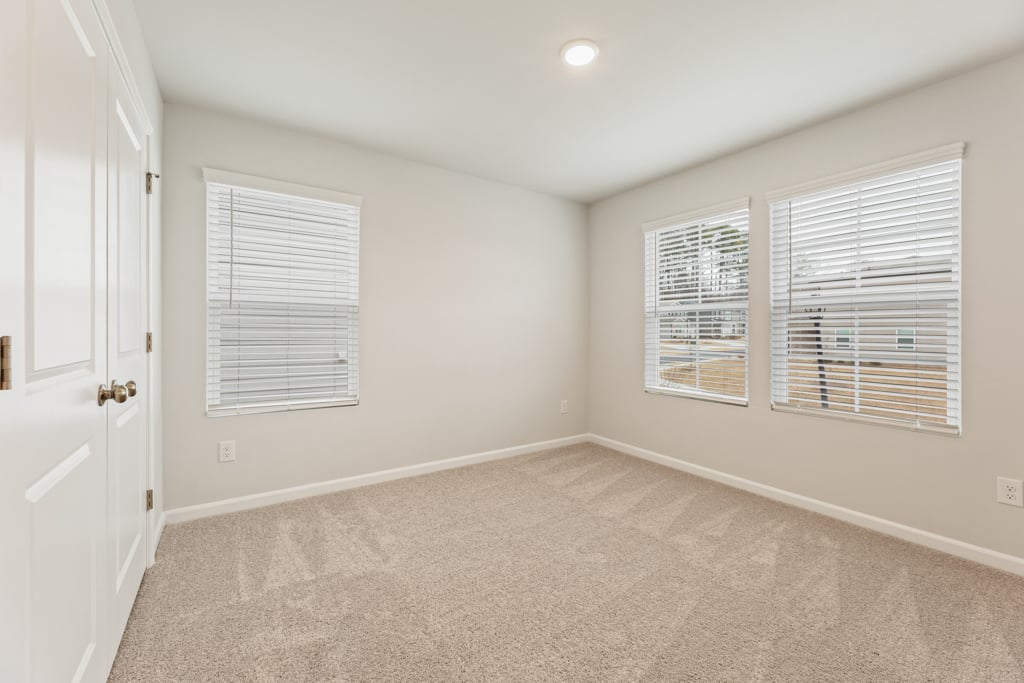 A room with white walls and a carpet.