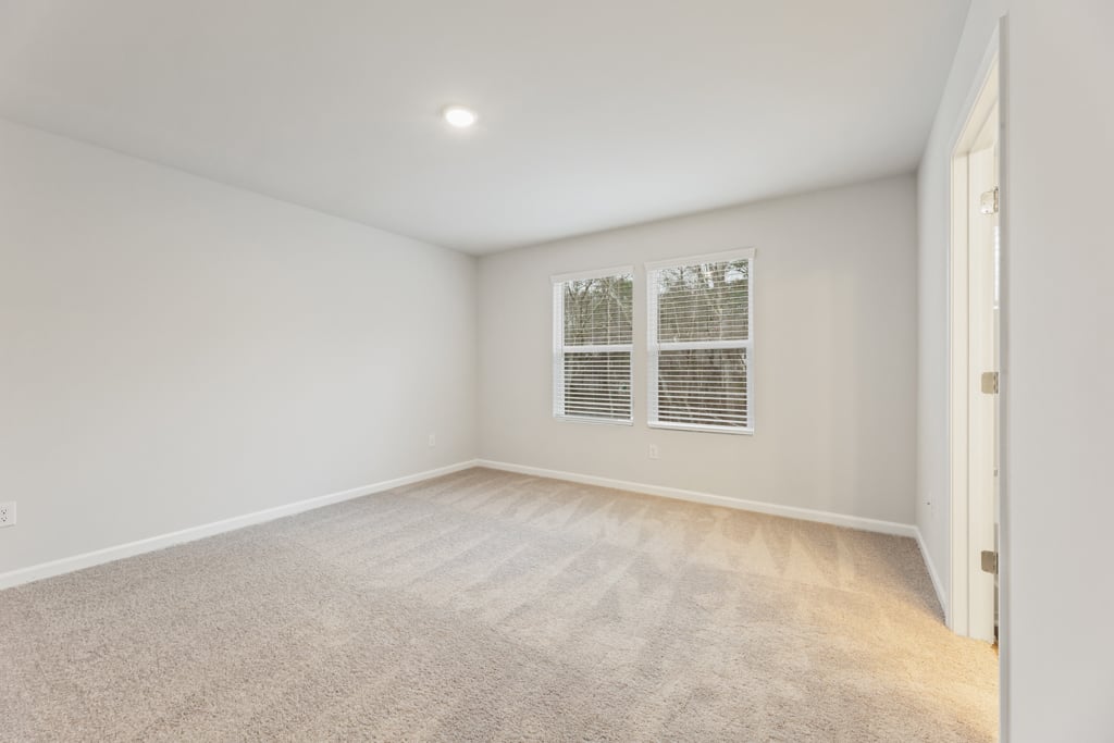 A room with a carpet and a window.