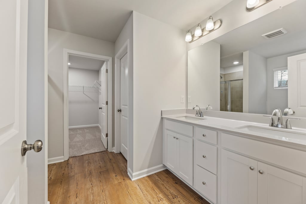 A bathroom with white cabinets.
