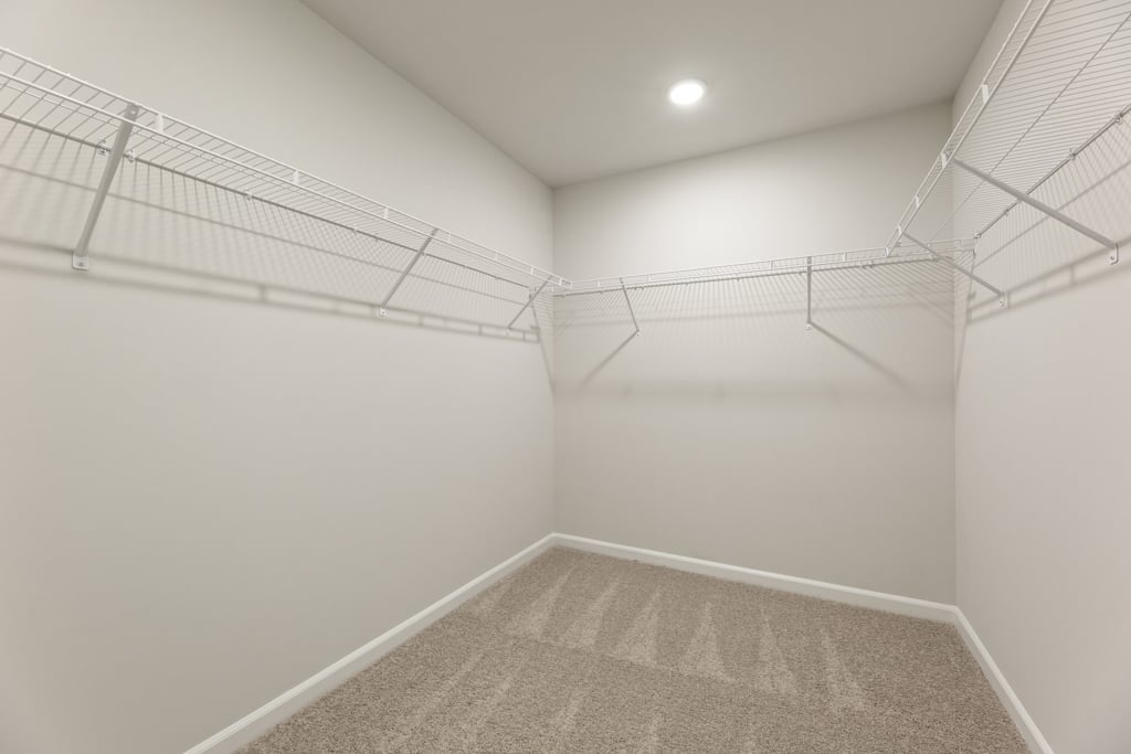 A white hallway with a metal railing.