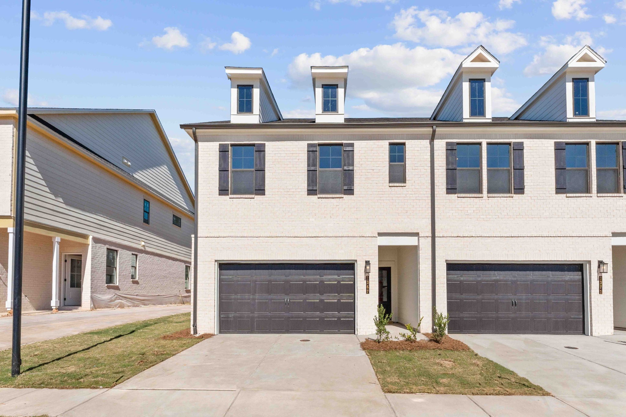 A white house with garages.