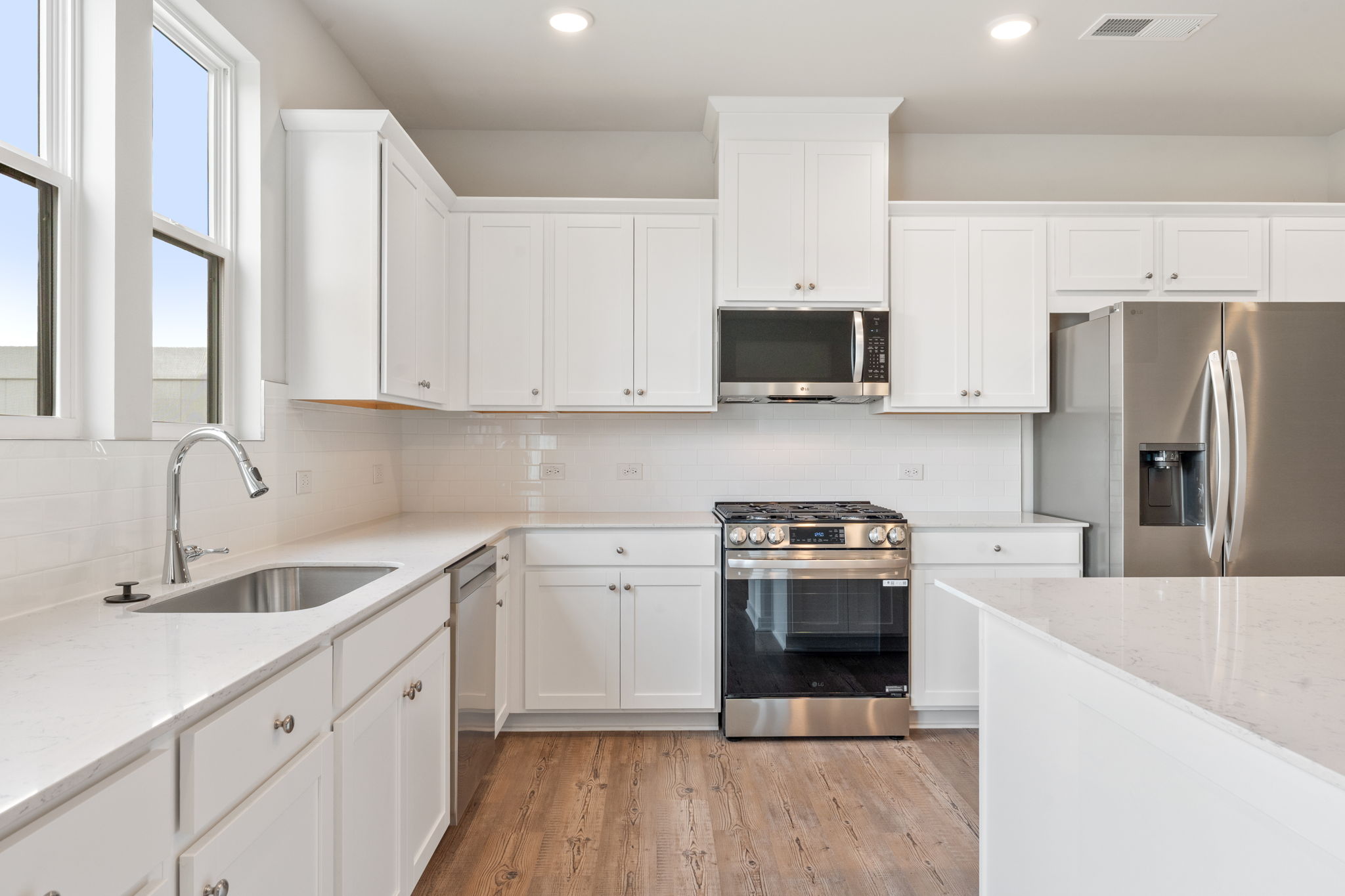 A kitchen with white cabinets.