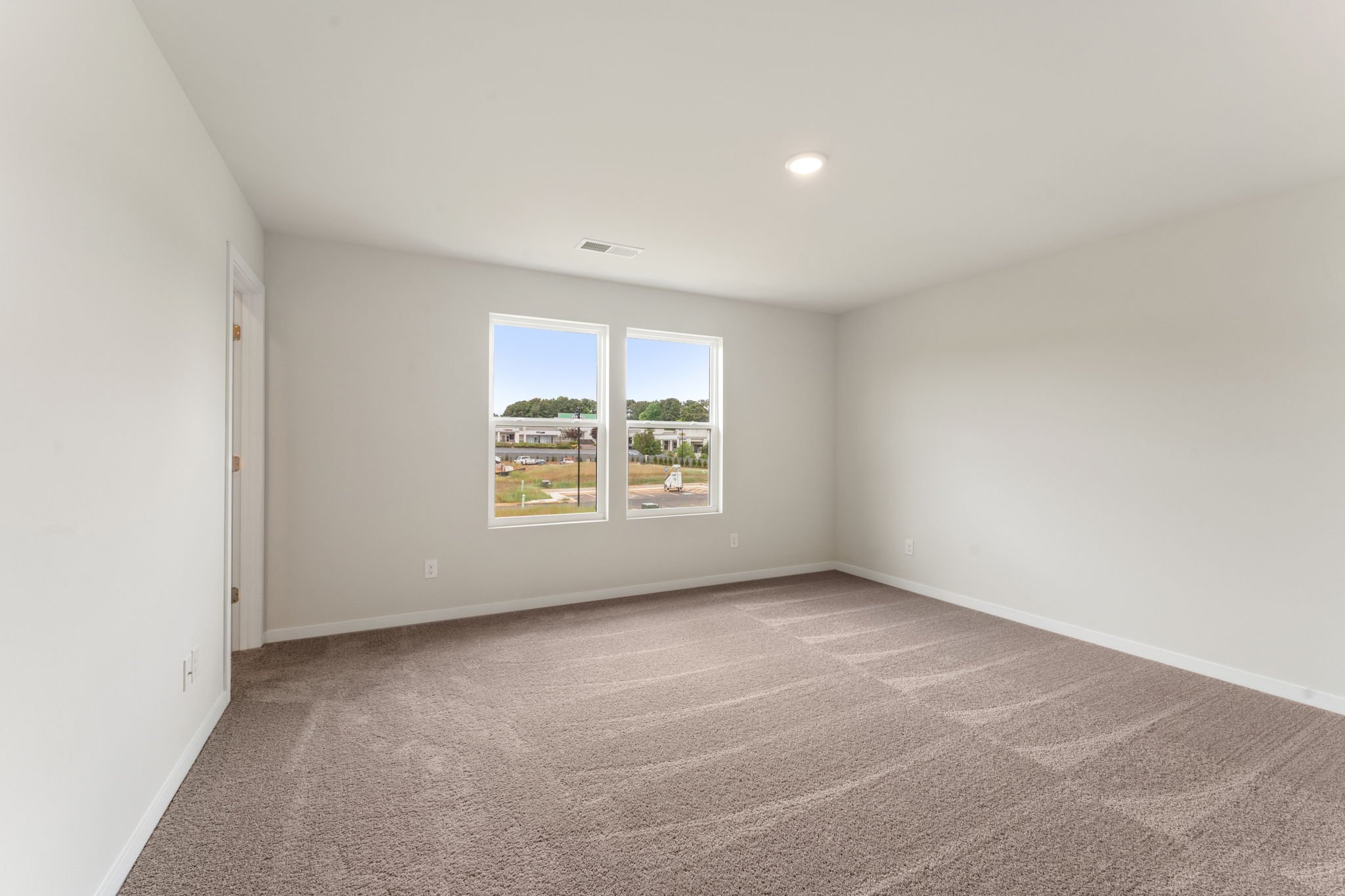 A room with a window and a carpet.