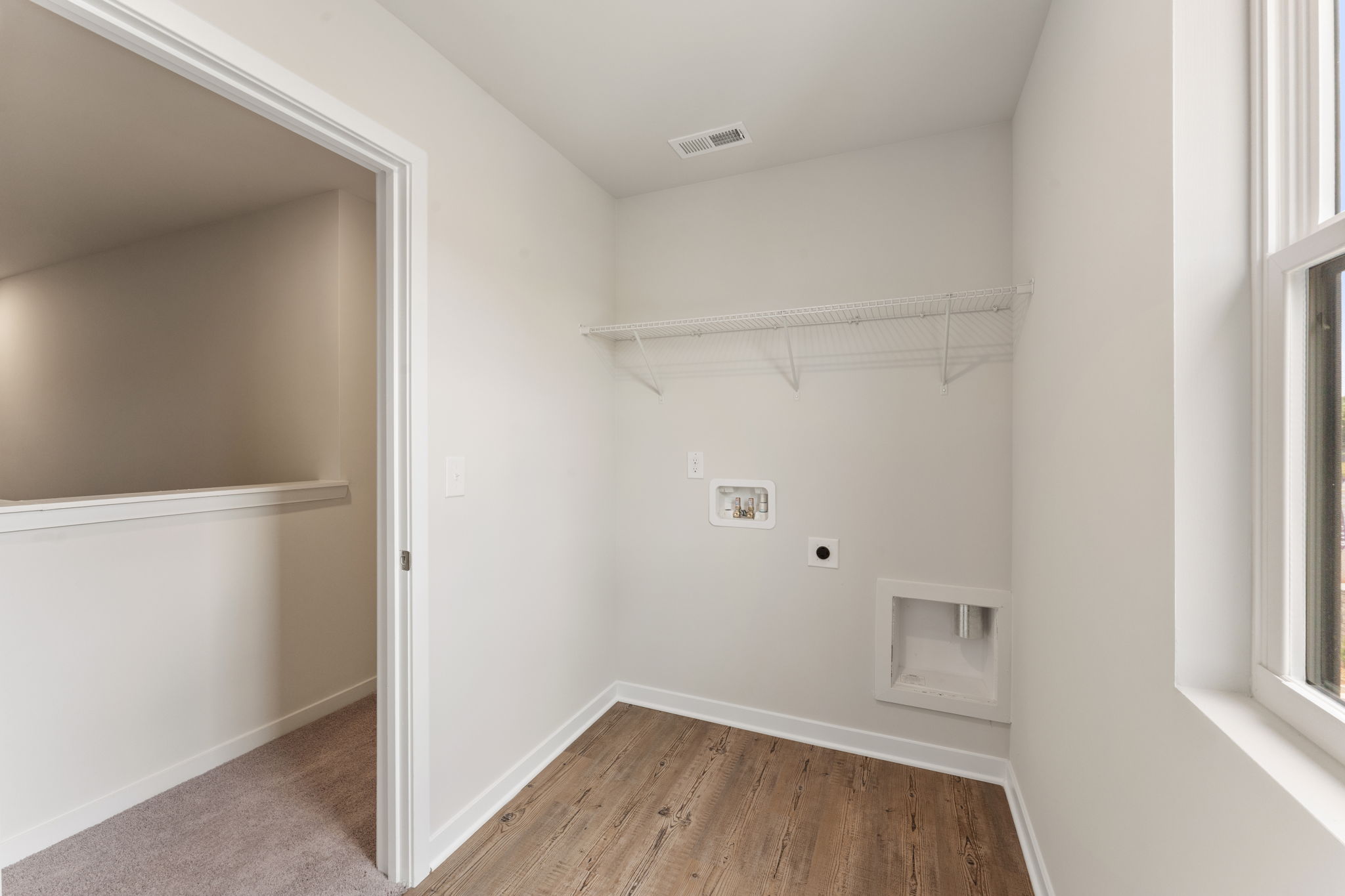 A room with a wood floor and white walls.