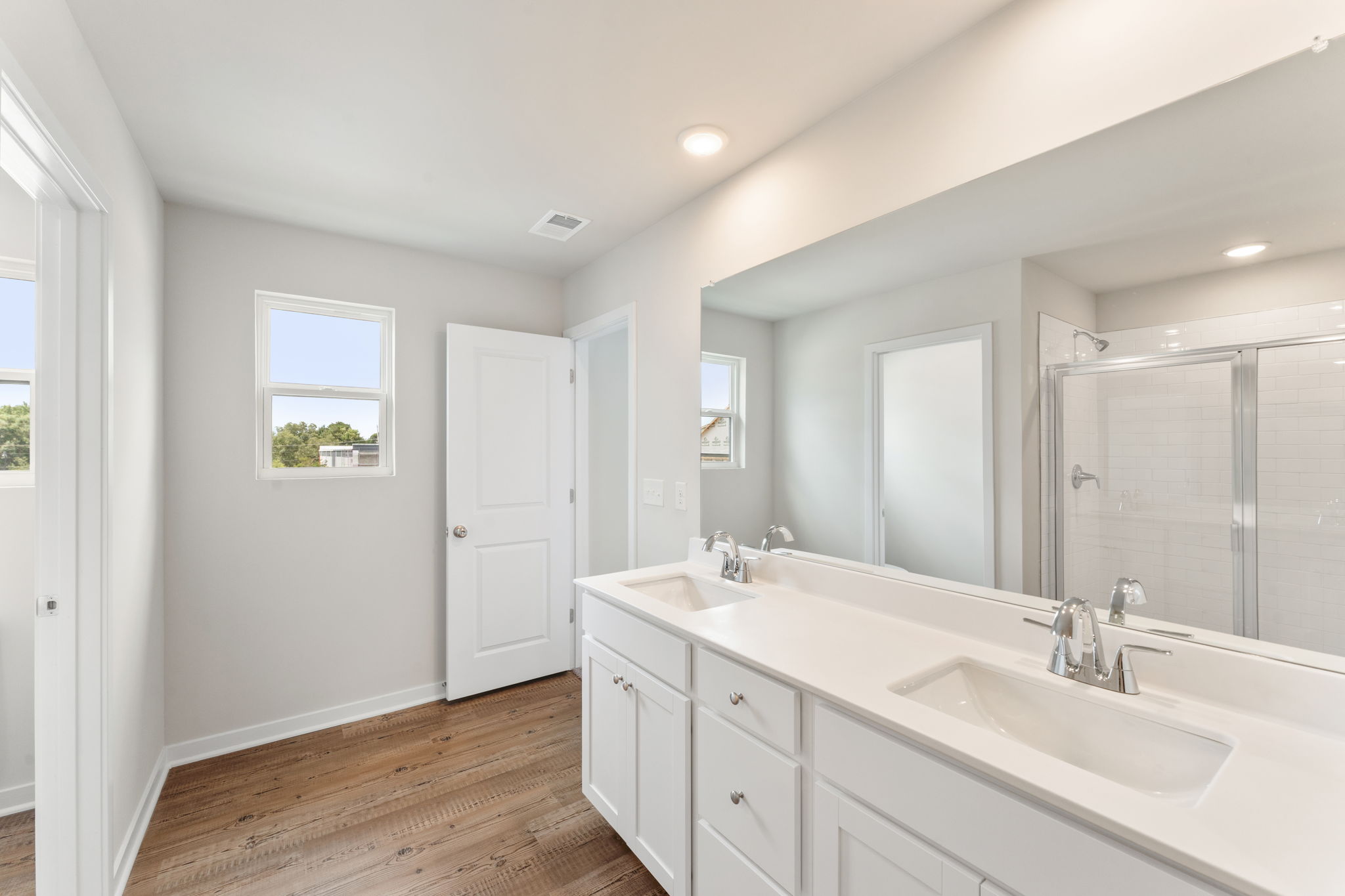 A bathroom with white cabinets.