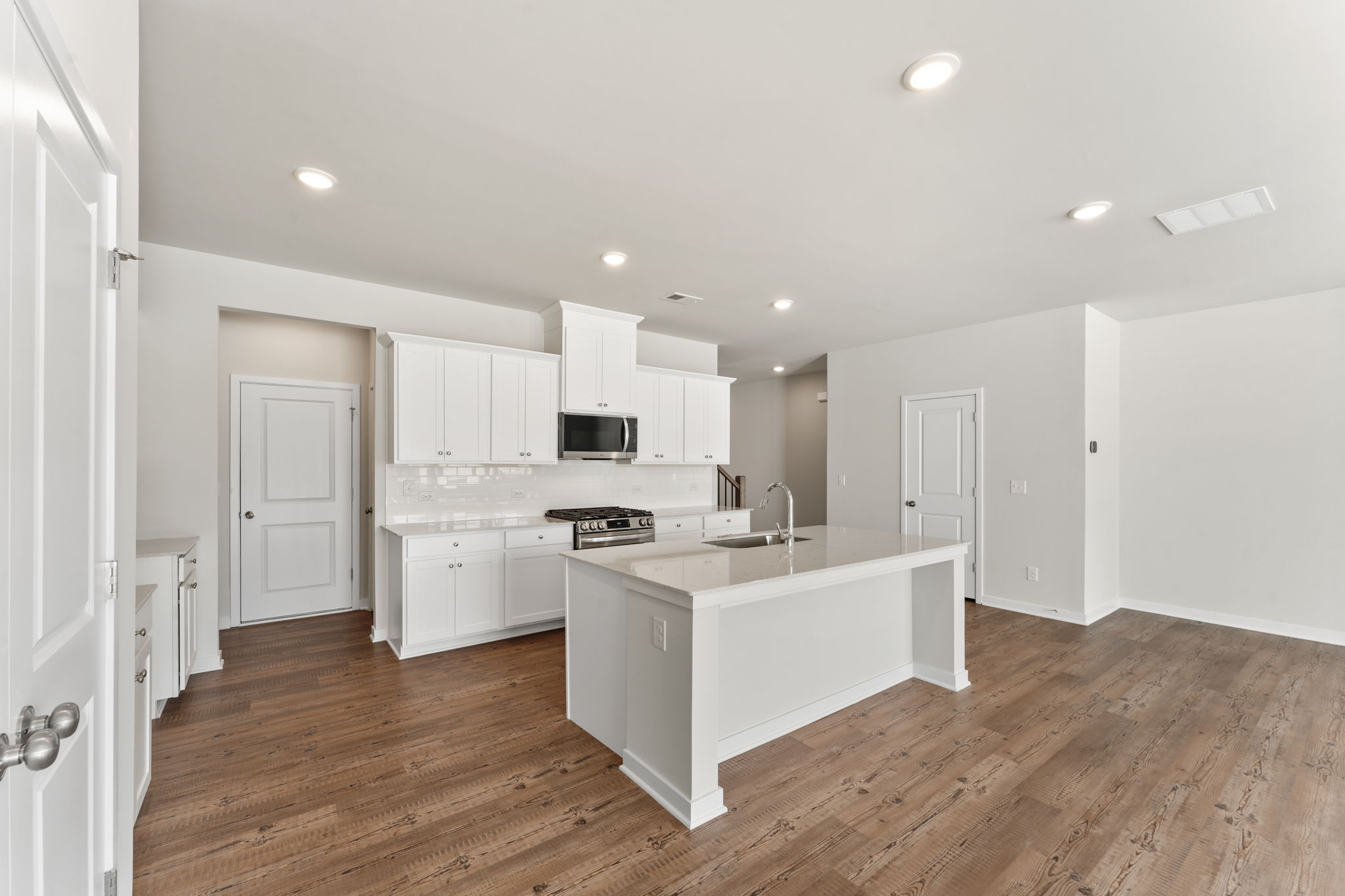 A kitchen with white cabinets.