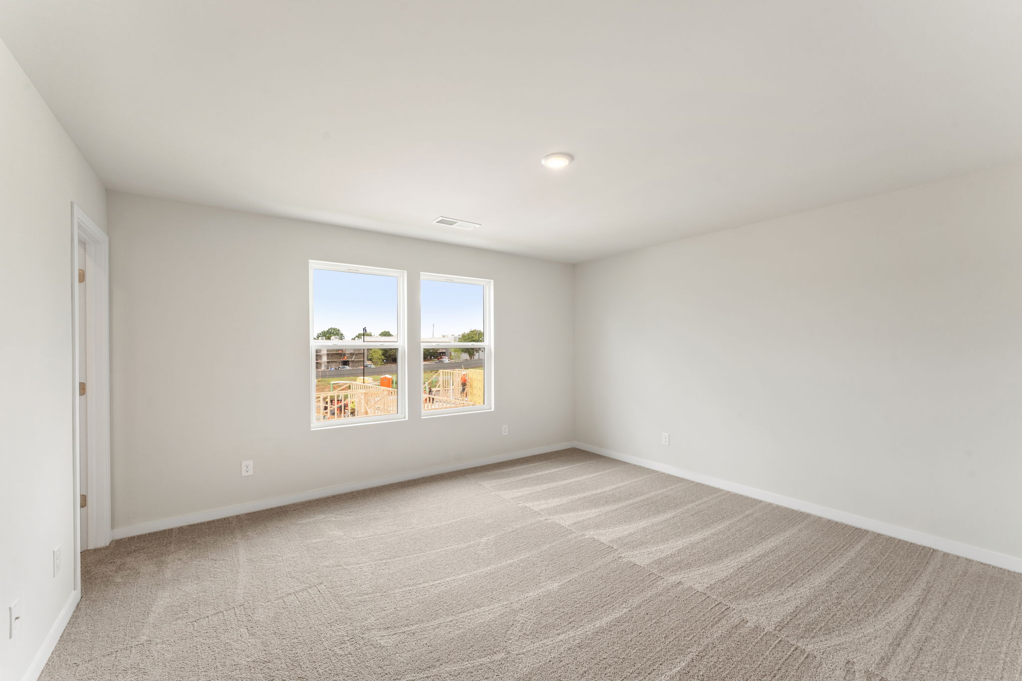 A room with a window and a rug.