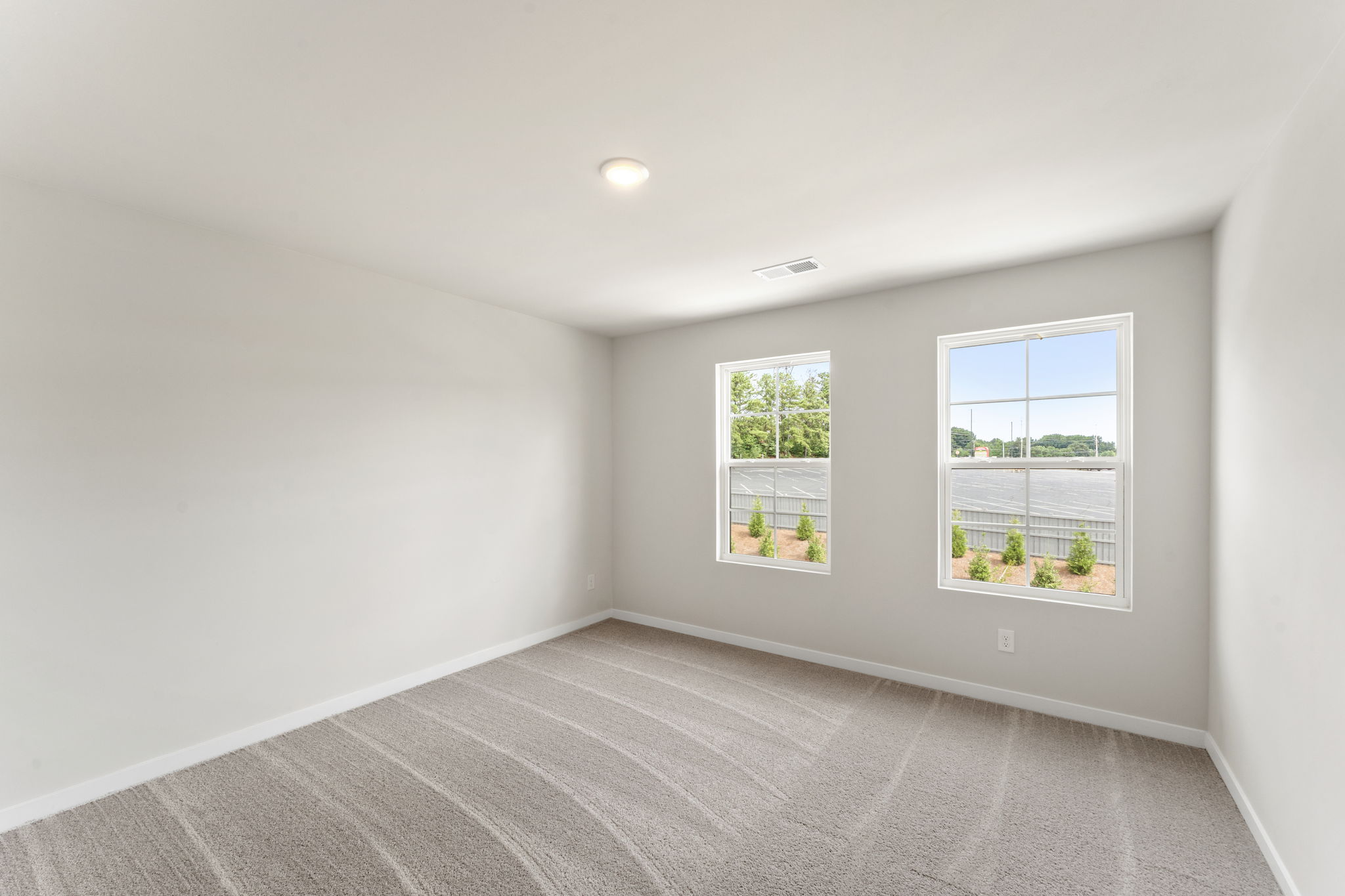 A room with windows and a carpet.