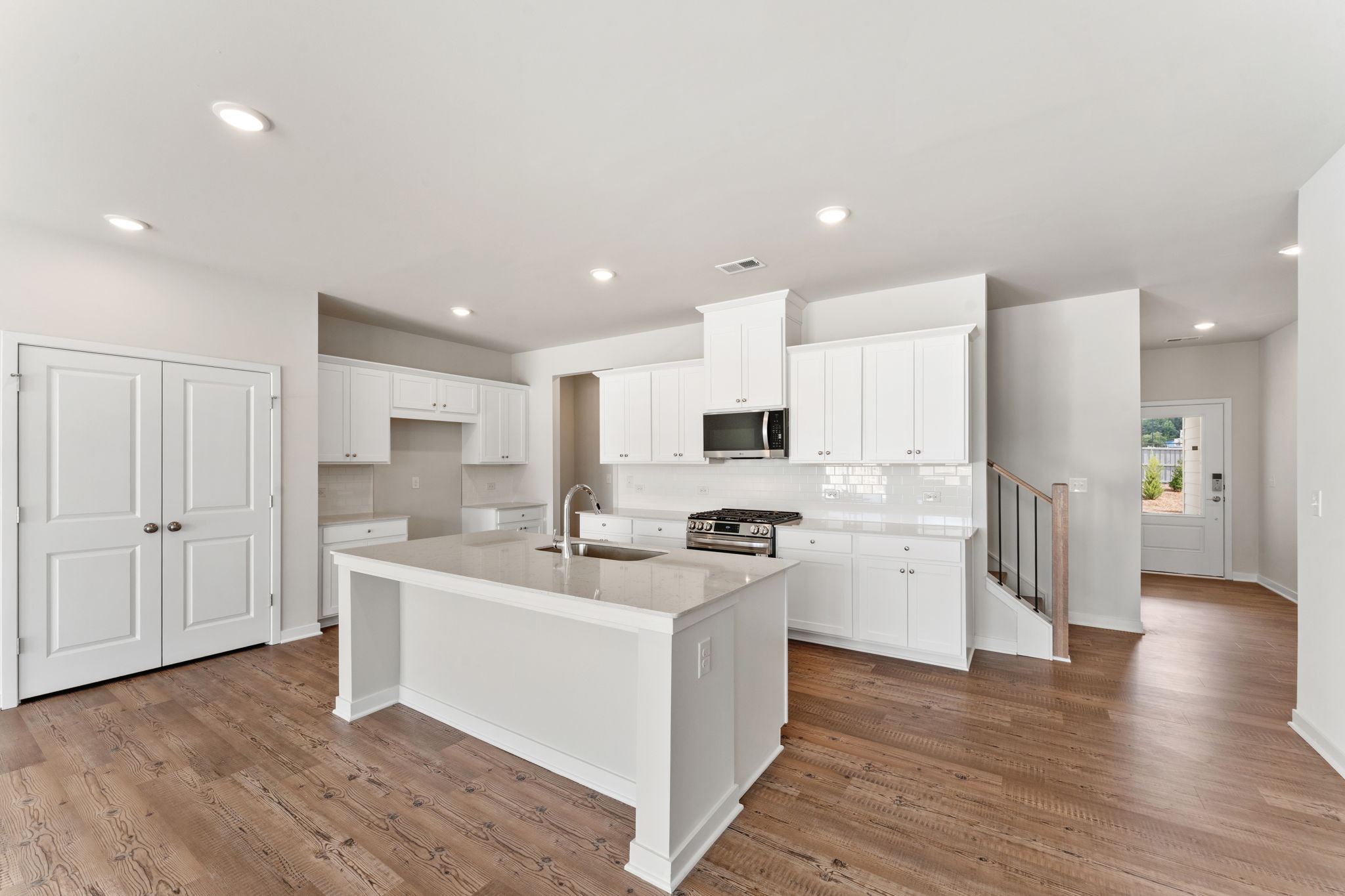 A kitchen with white cabinets.