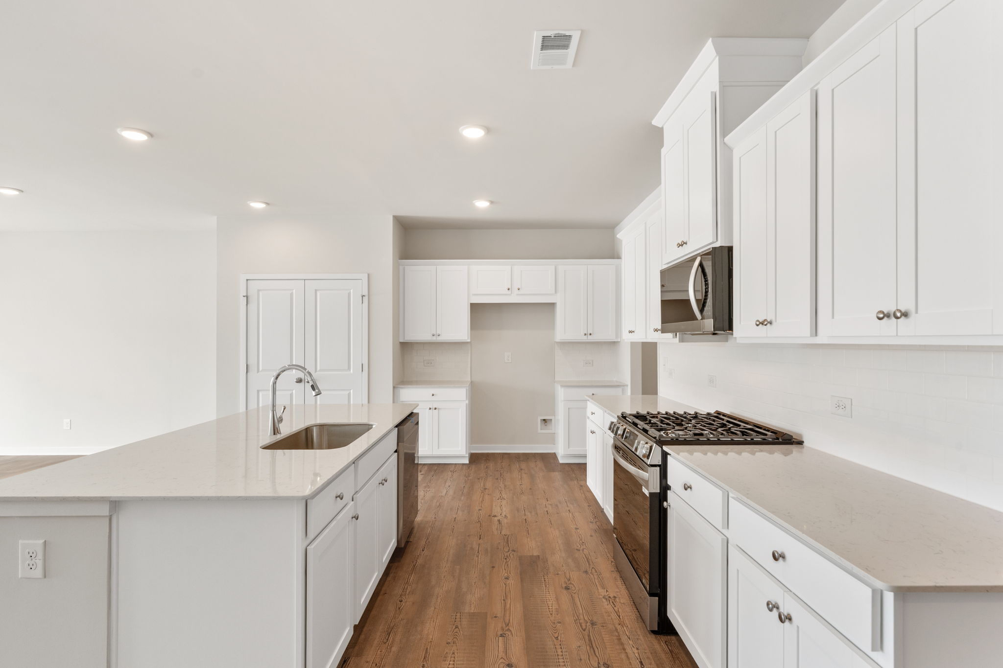 A kitchen with white cabinets.