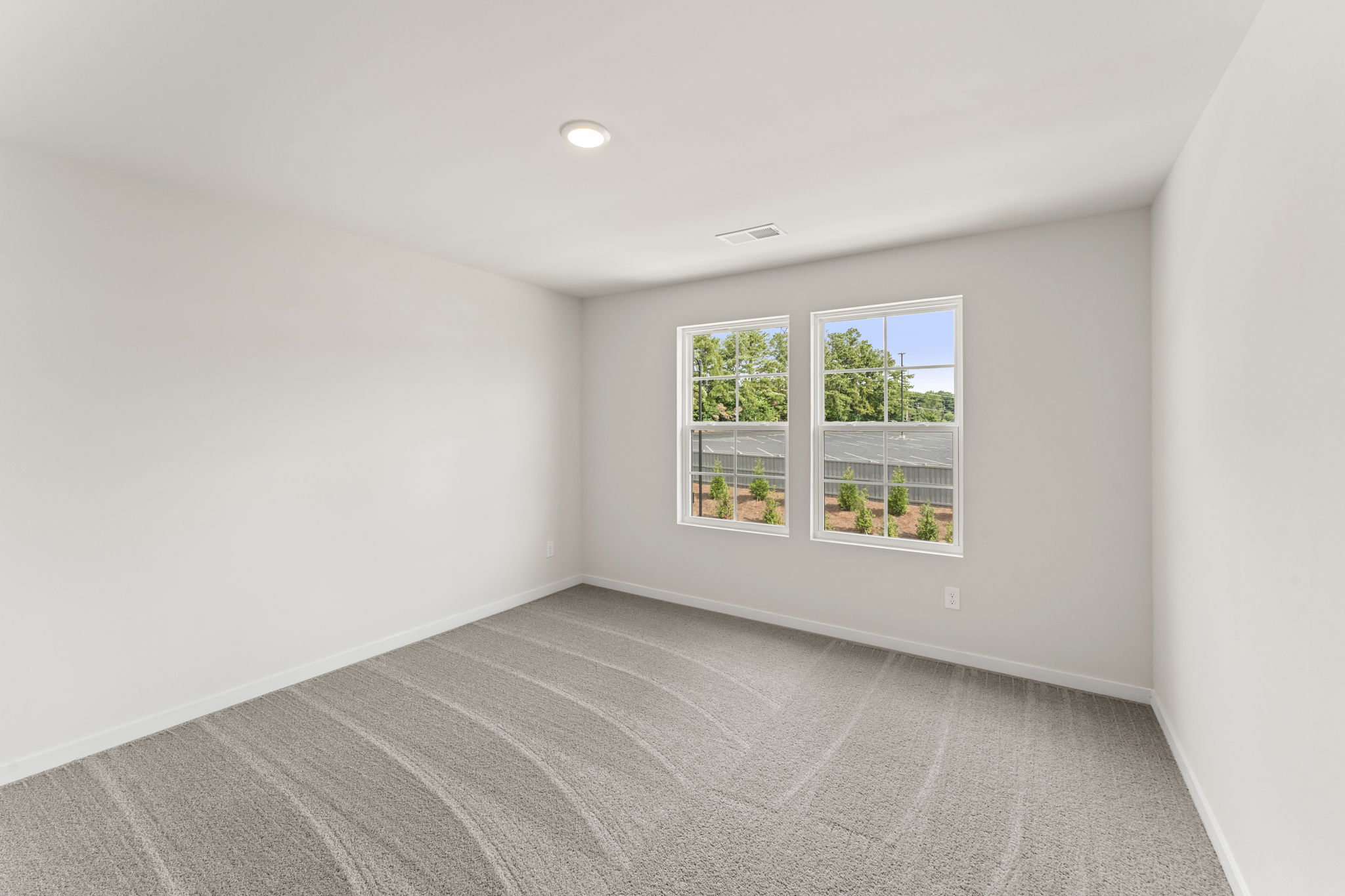 A room with a carpet and a window.