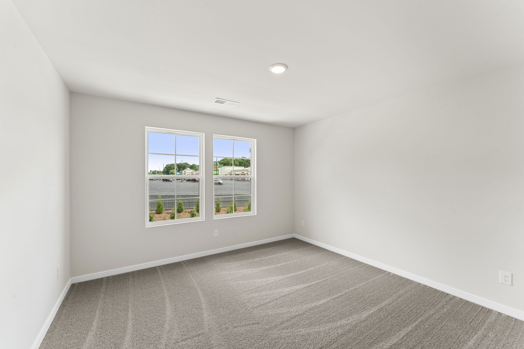 A room with a window and a carpet.