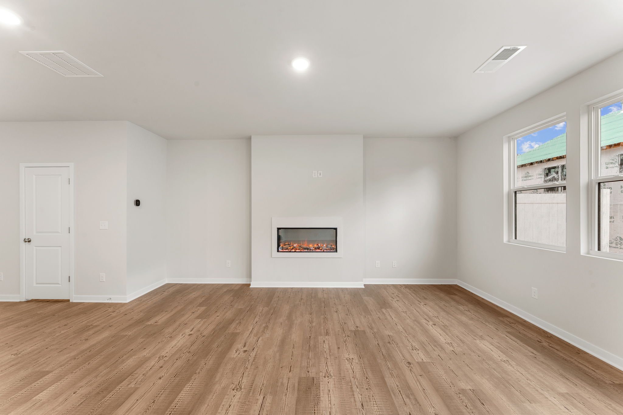 A room with white walls and a wood floor.