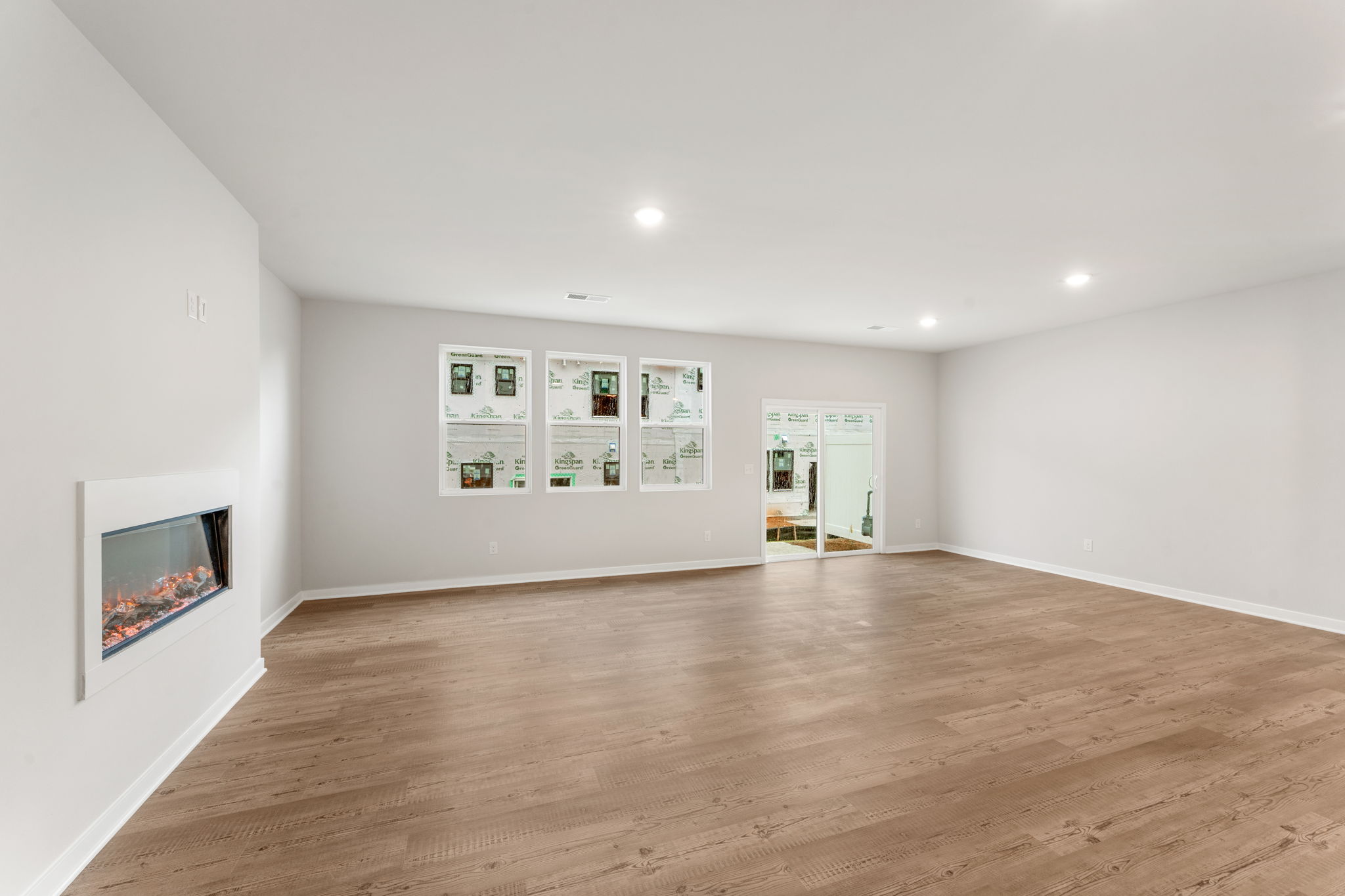 A room with a wood floor and a wood floor with pictures on the wall.