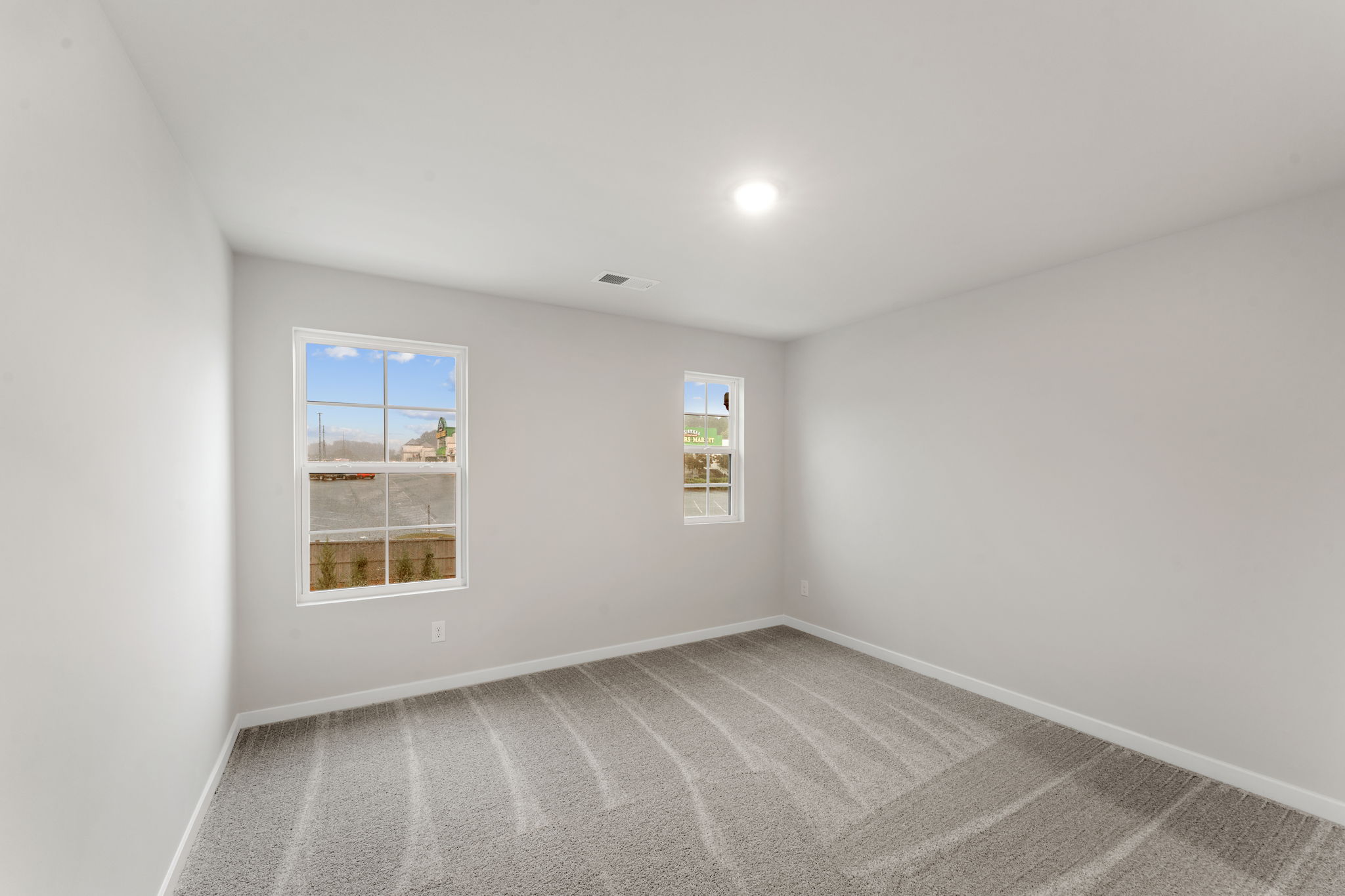 A room with a carpet and a window.