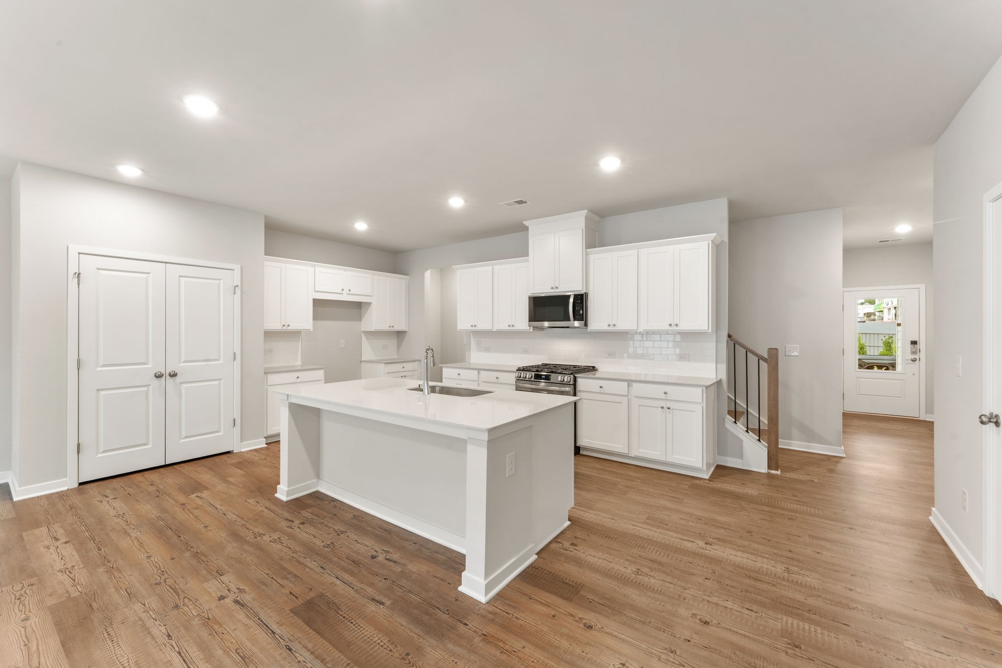 A kitchen with white cabinets.