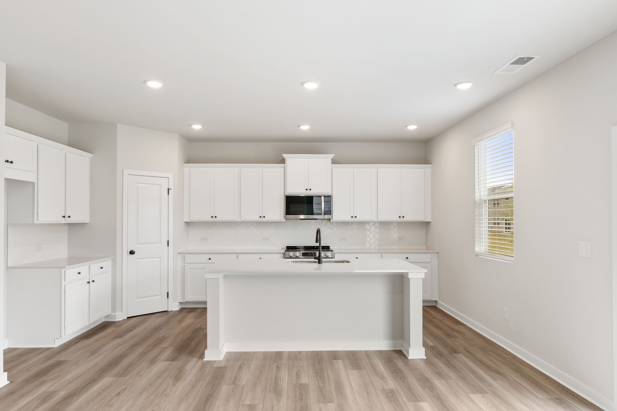 A kitchen with white cabinets.