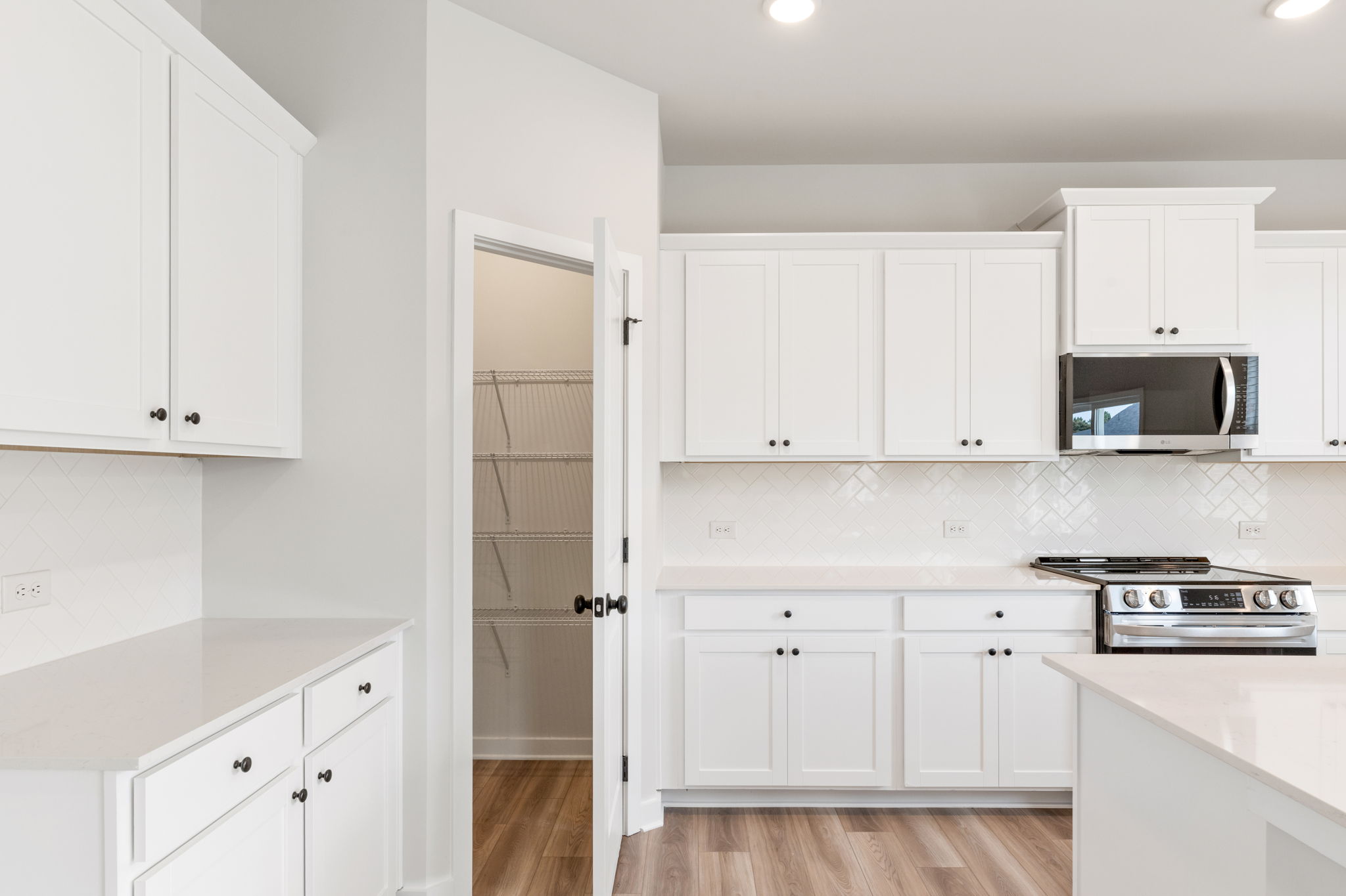 A kitchen with white cabinets.