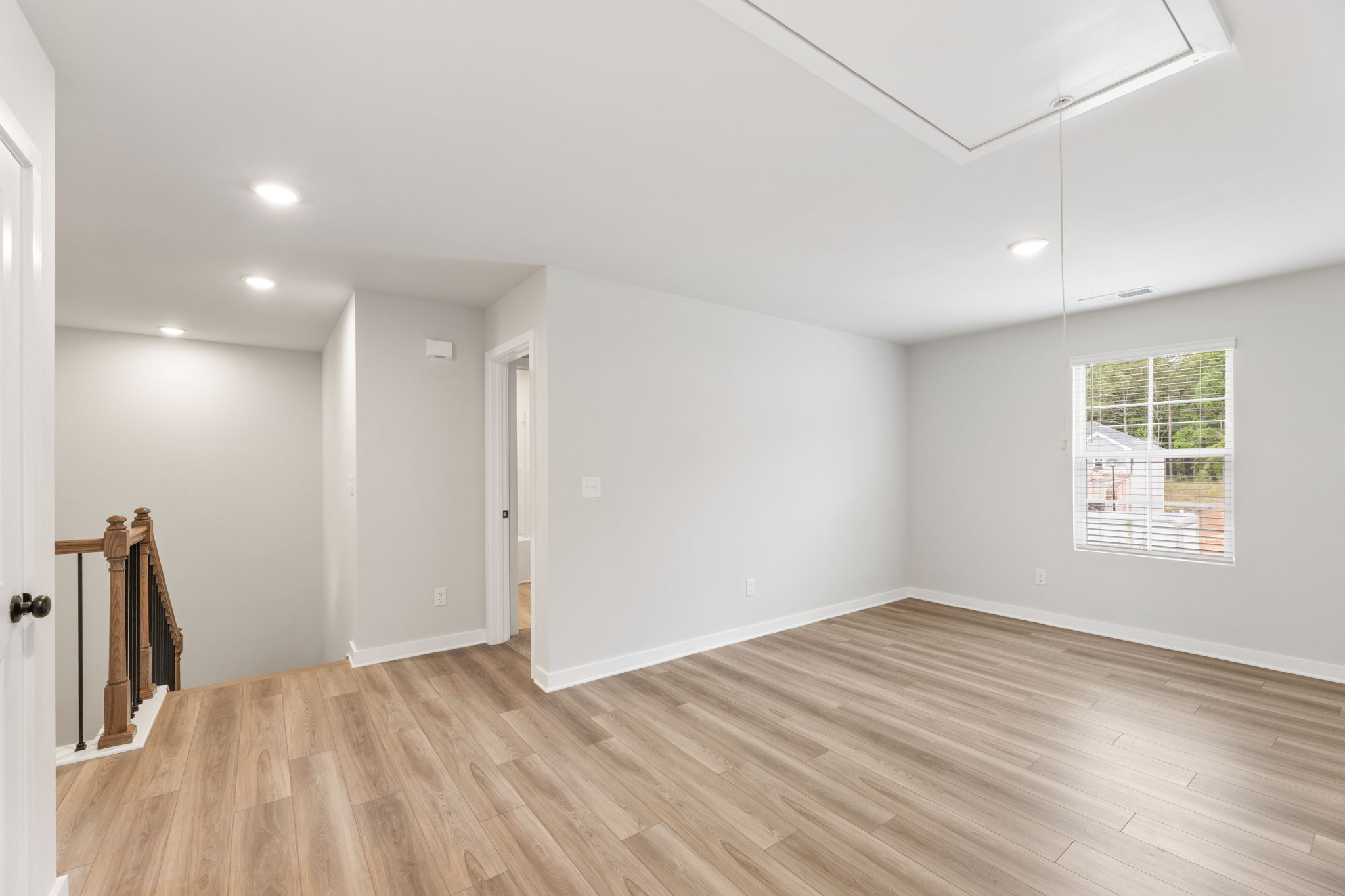 A room with a wood floor and white walls.