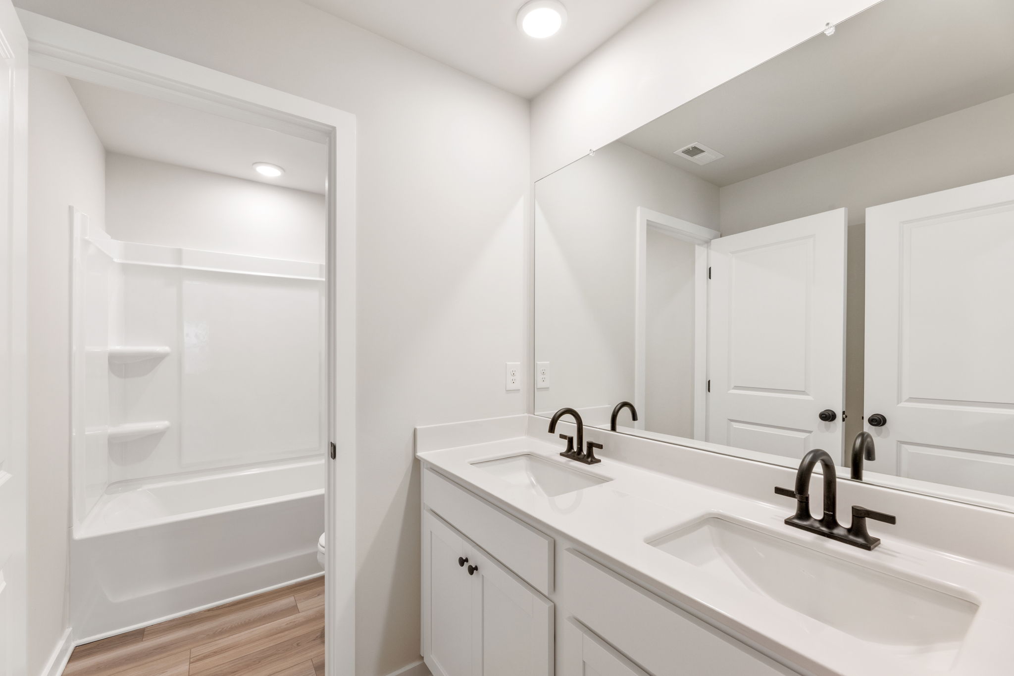 A bathroom with white cabinets.