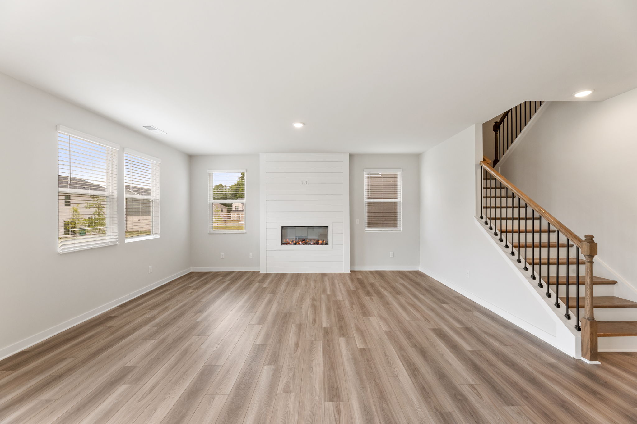 A room with a wood floor and a staircase.