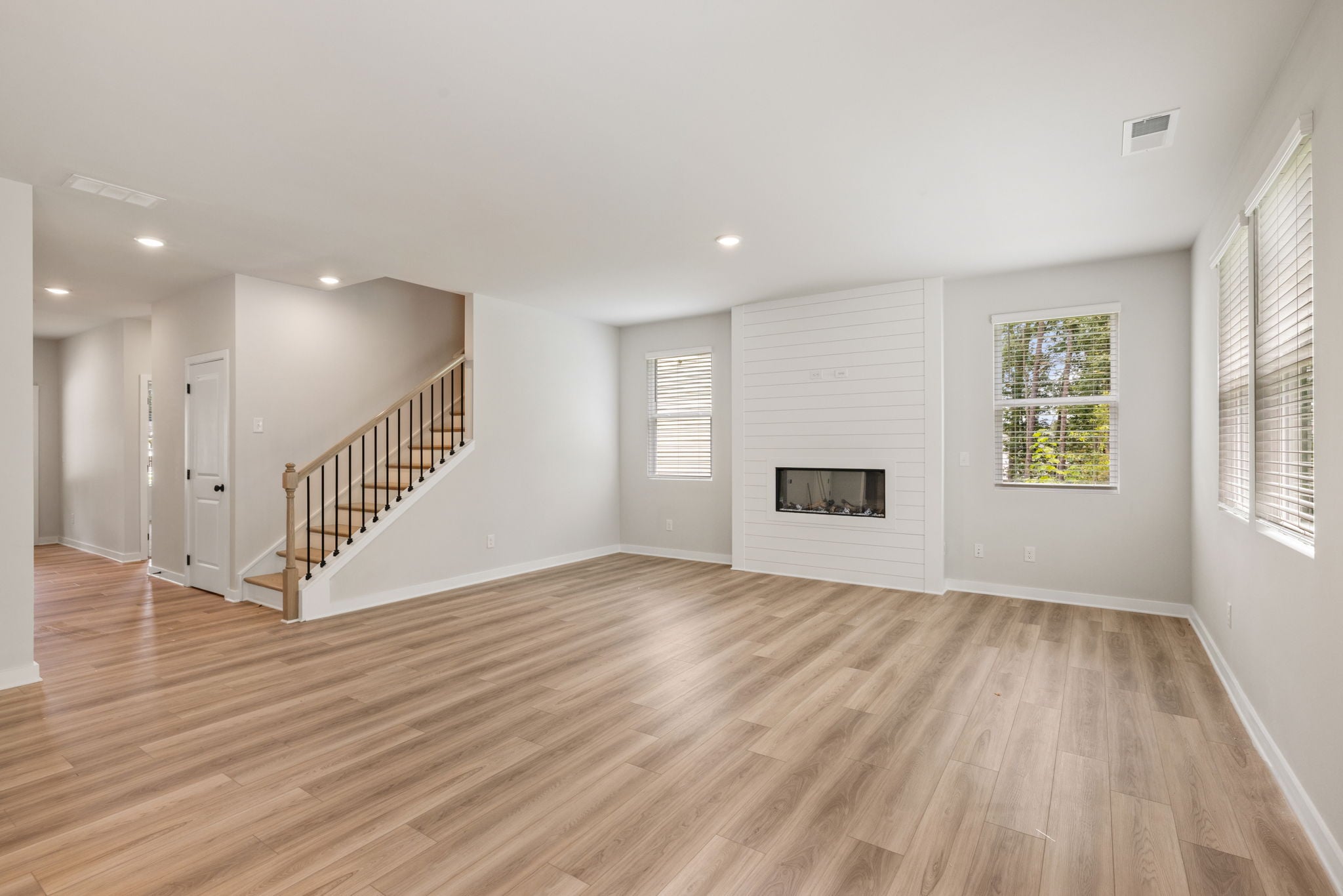 A room with a wood floor and a staircase.
