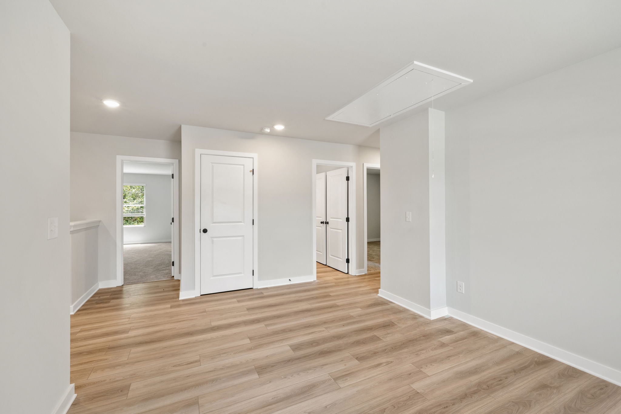 A room with white walls and wood floors.