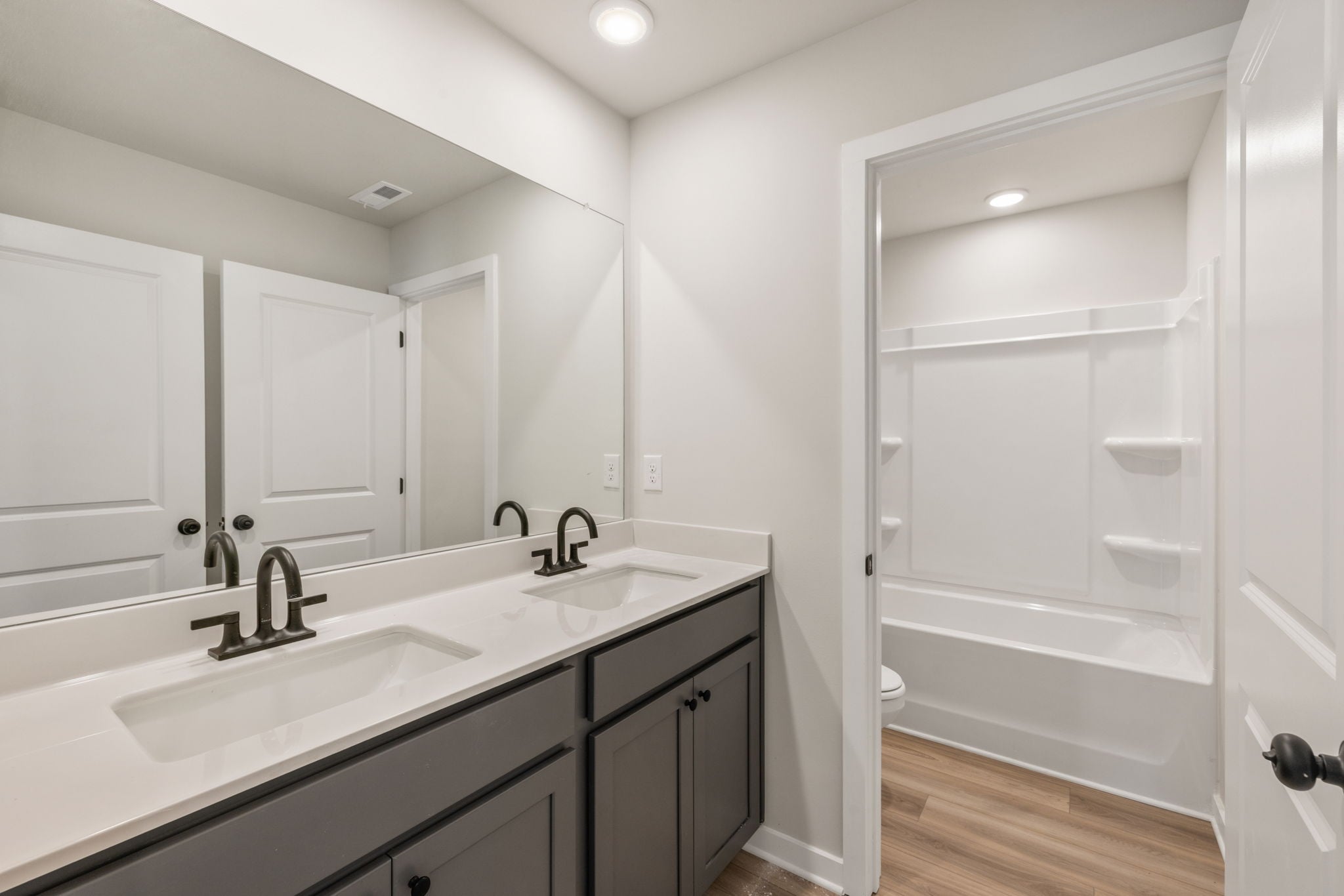 A bathroom with a sink and a shower unit.